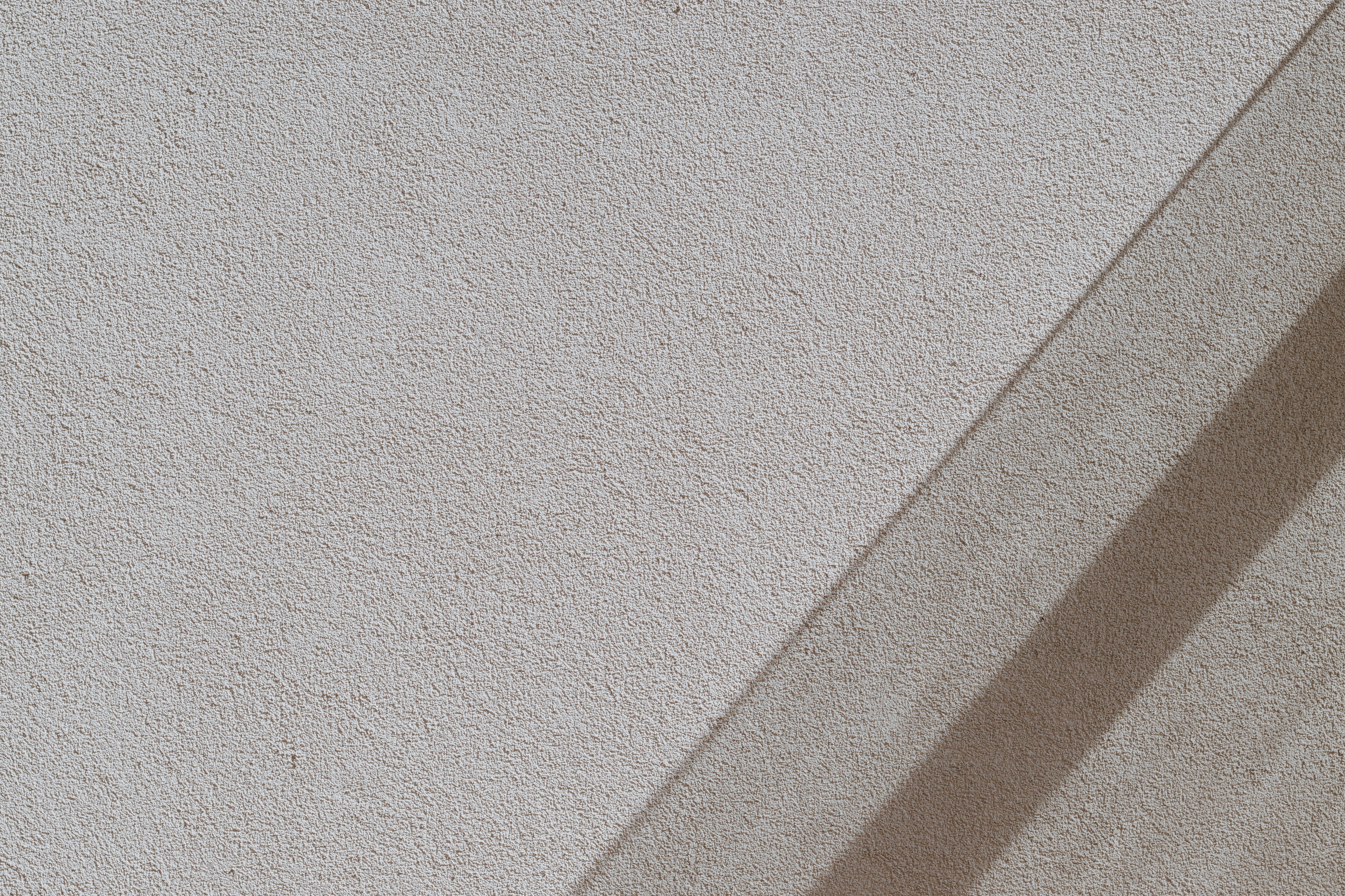 Textured white wall with diagonal shadow