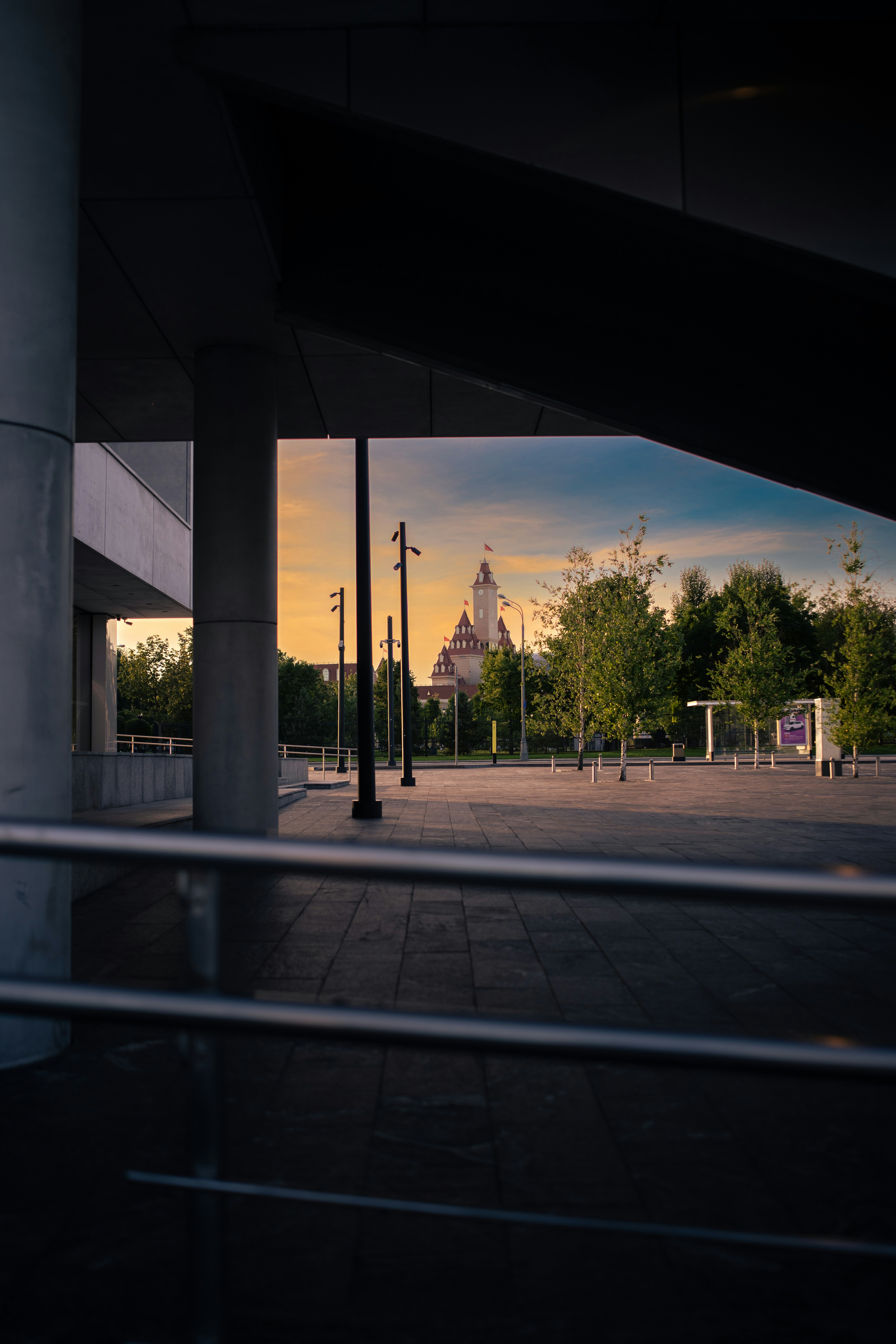 City building framed by concrete structures during an orange sunset.