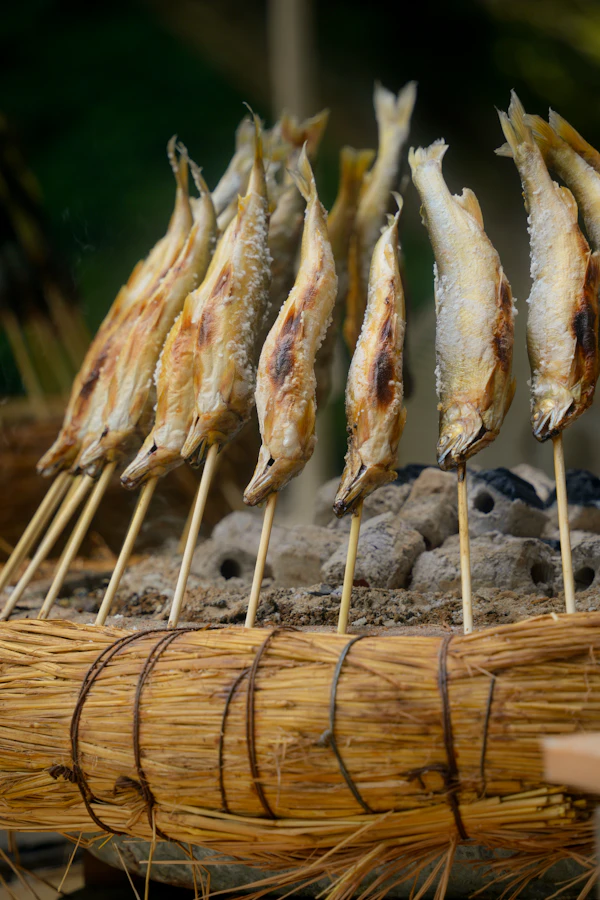 Whole fish grilled on skewers over coals