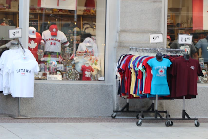 A storefront with canadian souvenirs and clothing racks outside