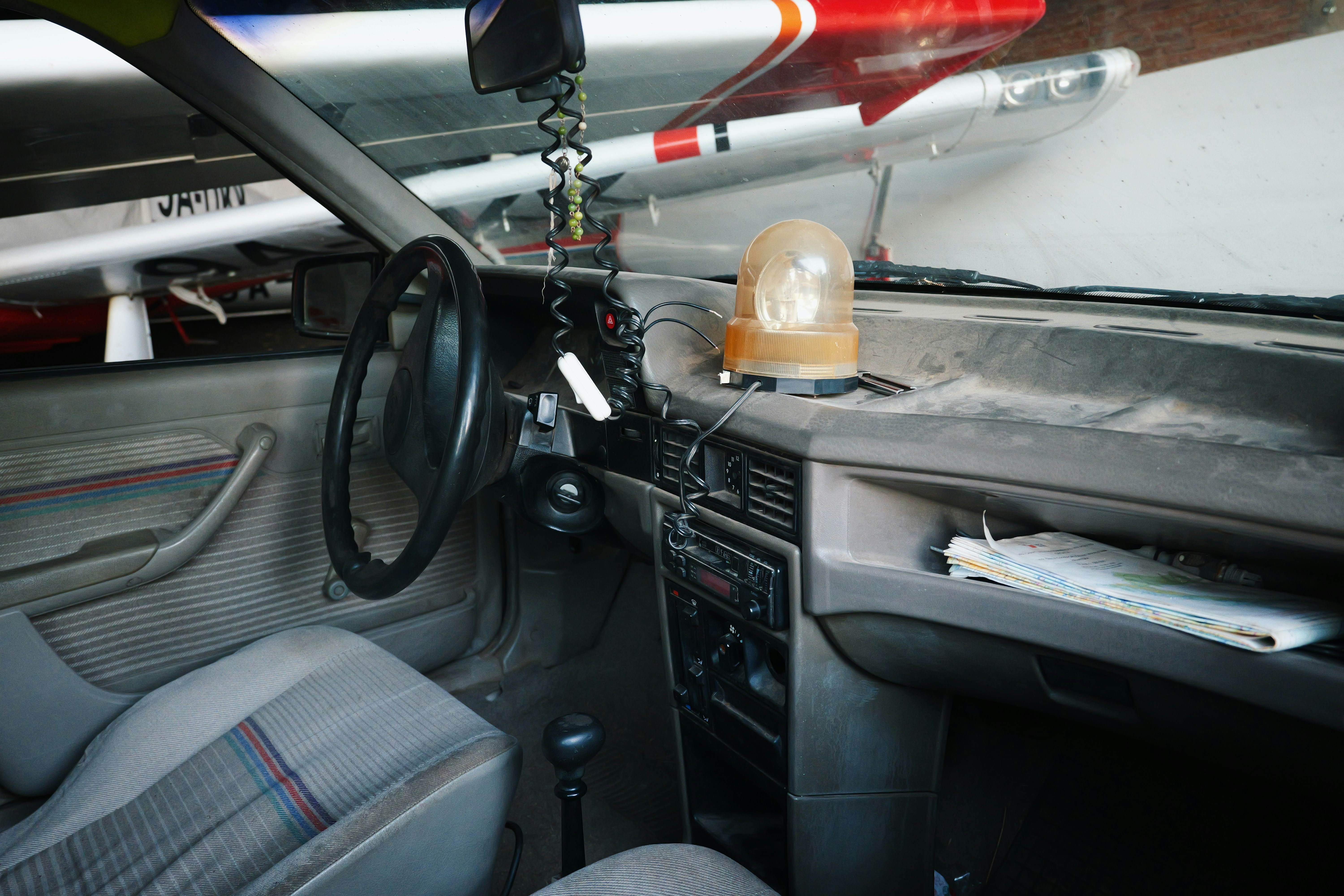 Old car interior with beacon light, airplanes visible in background