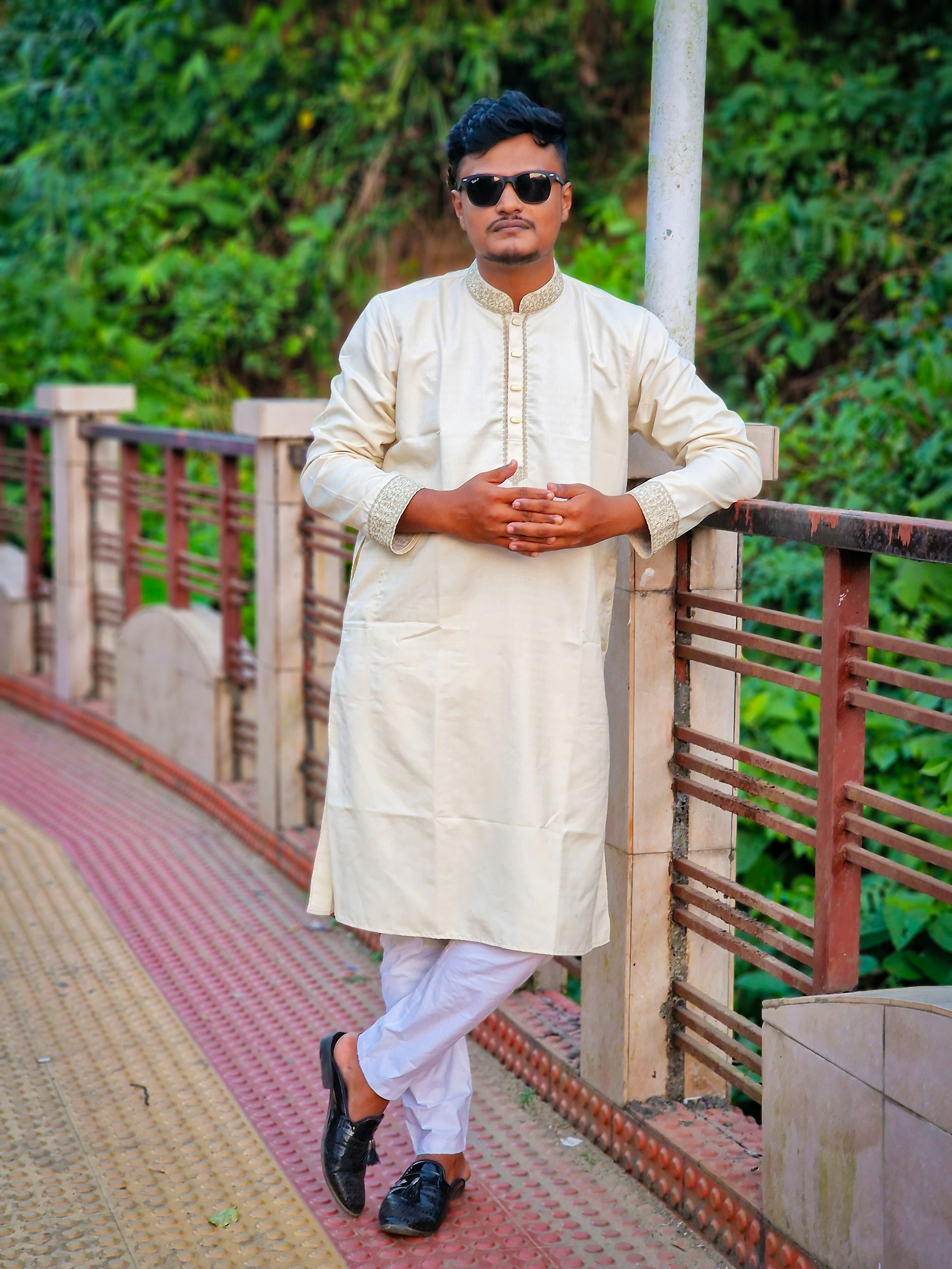 Jovem com kurta tradicional e óculos escuros em uma ponte
