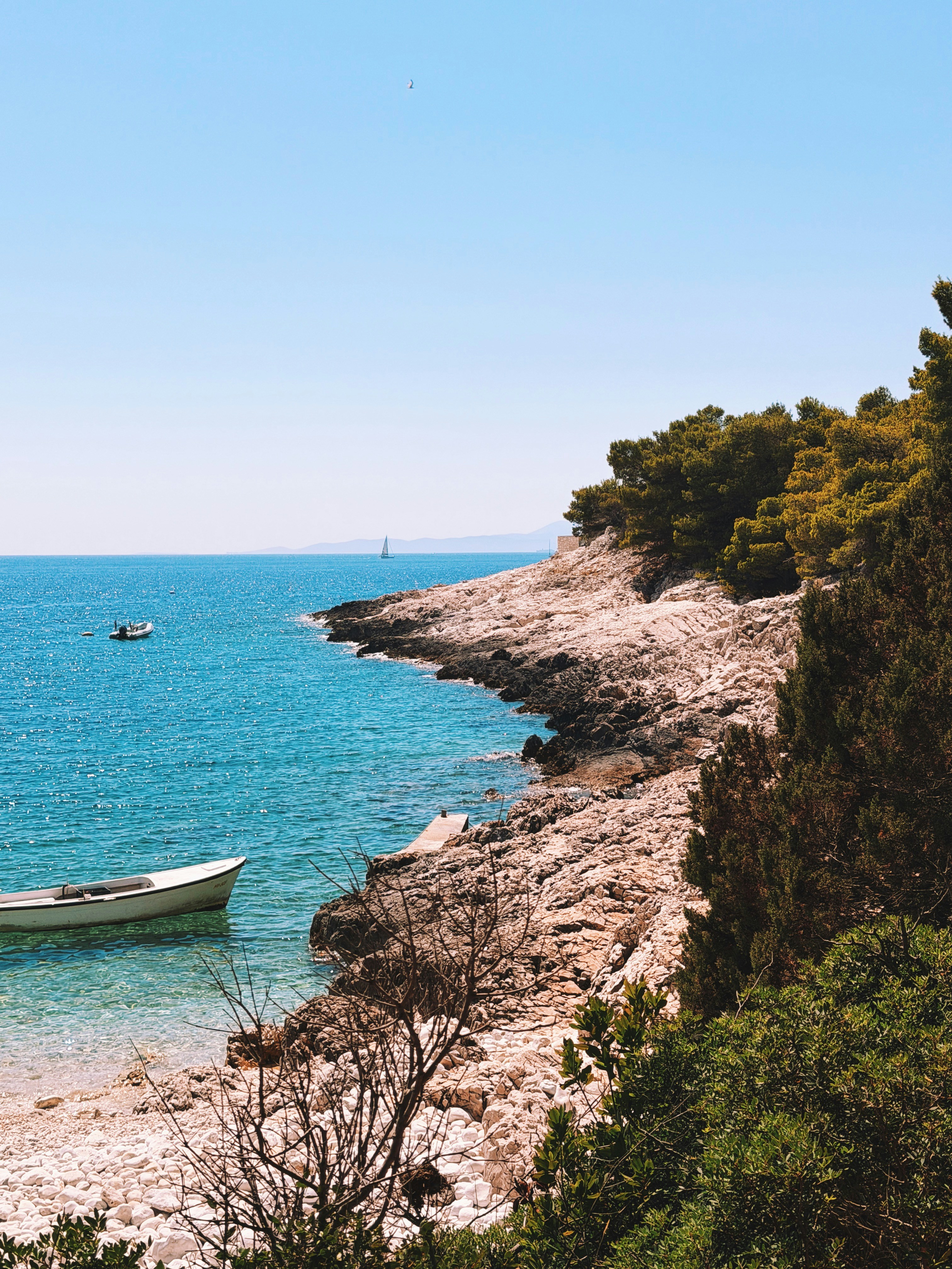Rocky coast with clear blue sea and a small boat