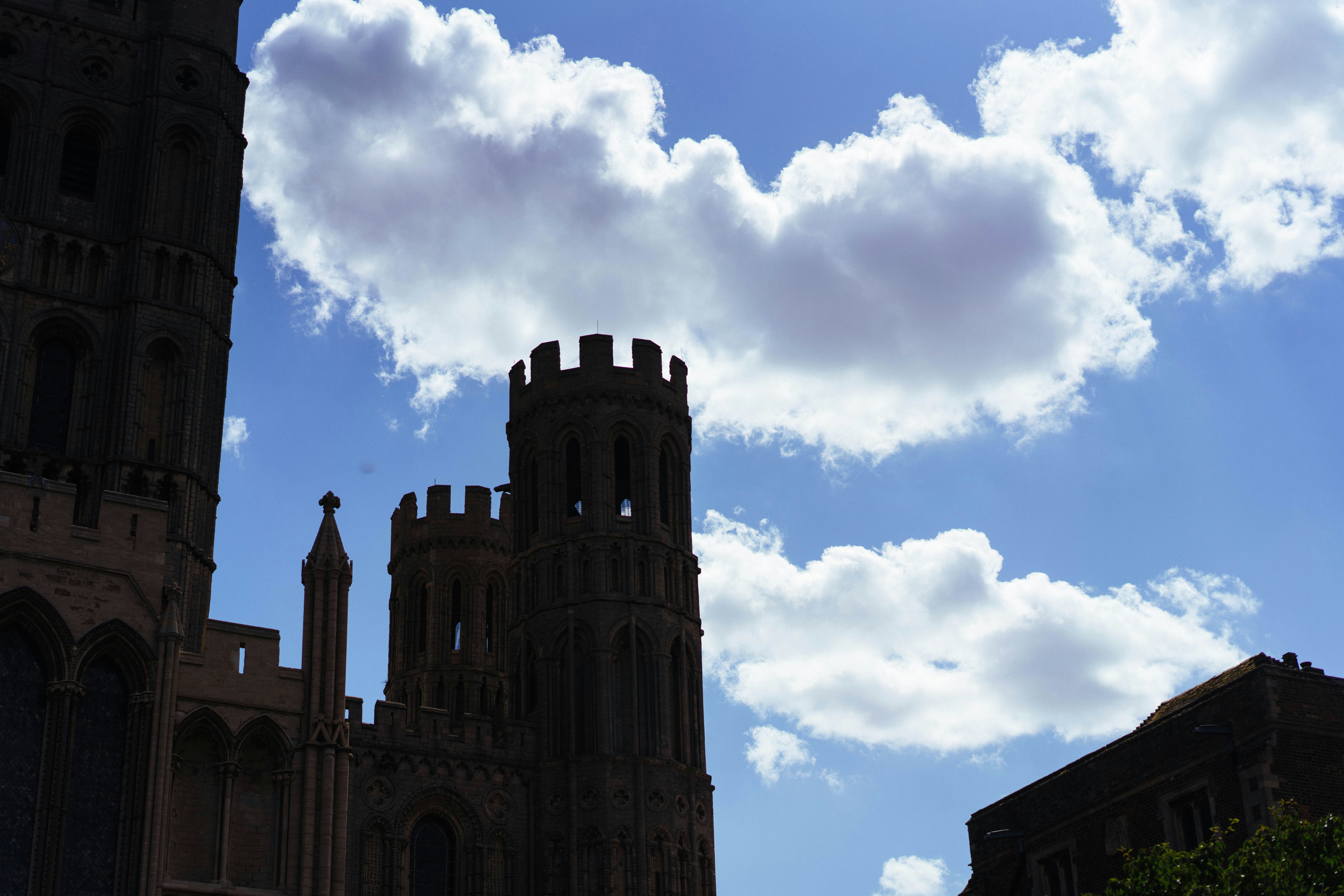 Ancient cathedral towers silhouetted against a cloudy blue sky.