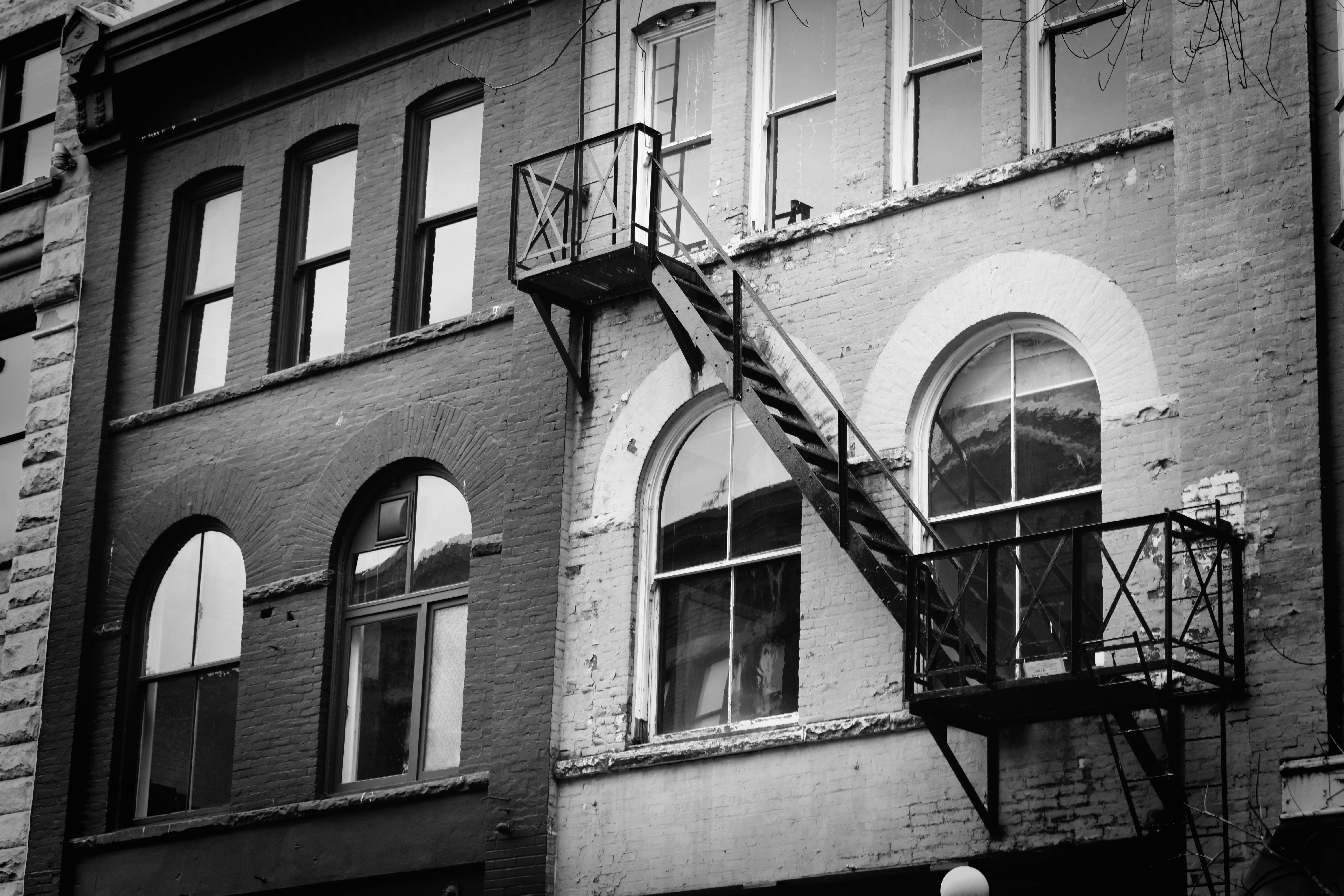 Historic buildings with arched windows and a prominent fire escape.
