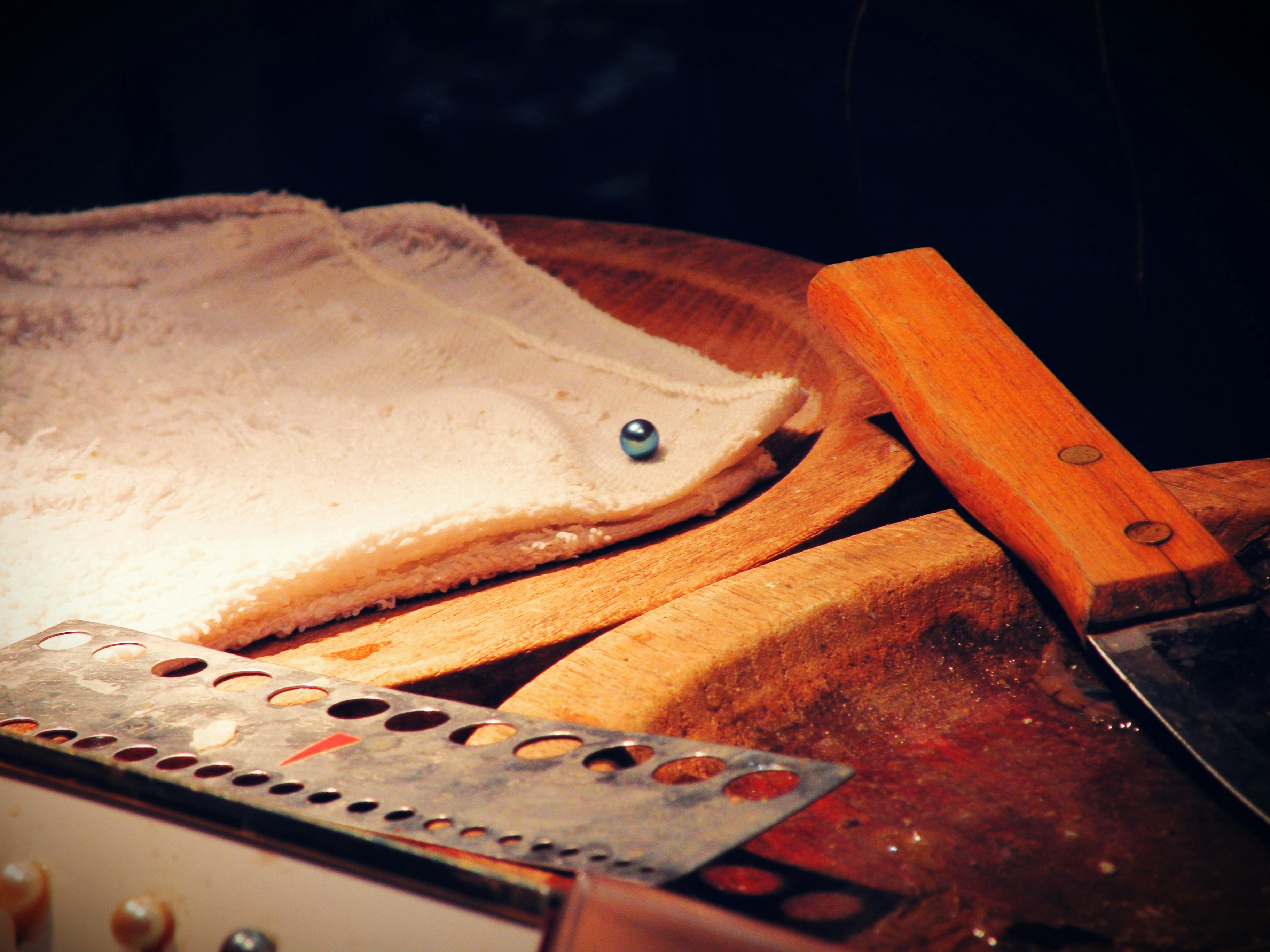 White dough, cleaver, and metal tool on a wooden board.
