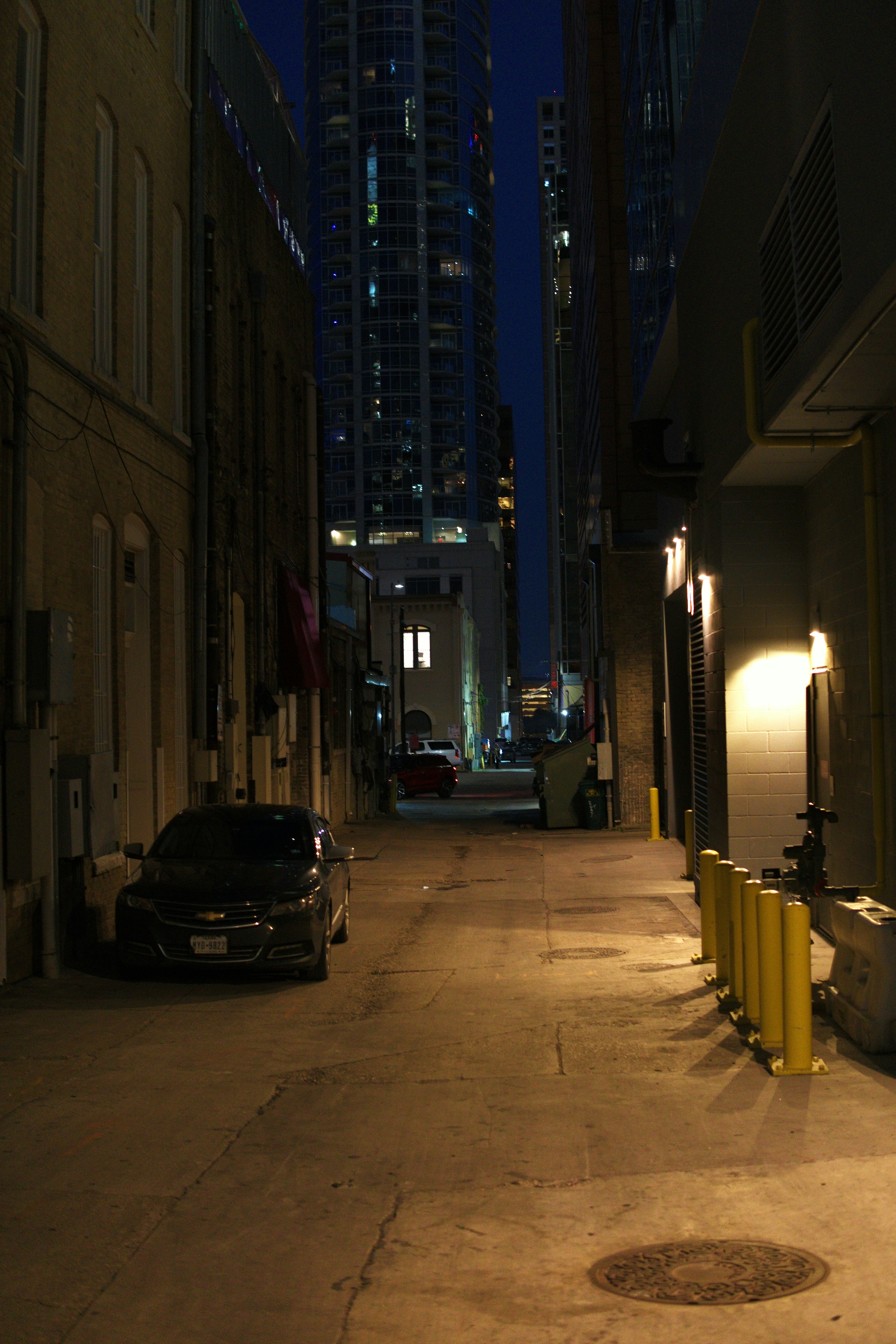 A dark city alley at night with a parked car
