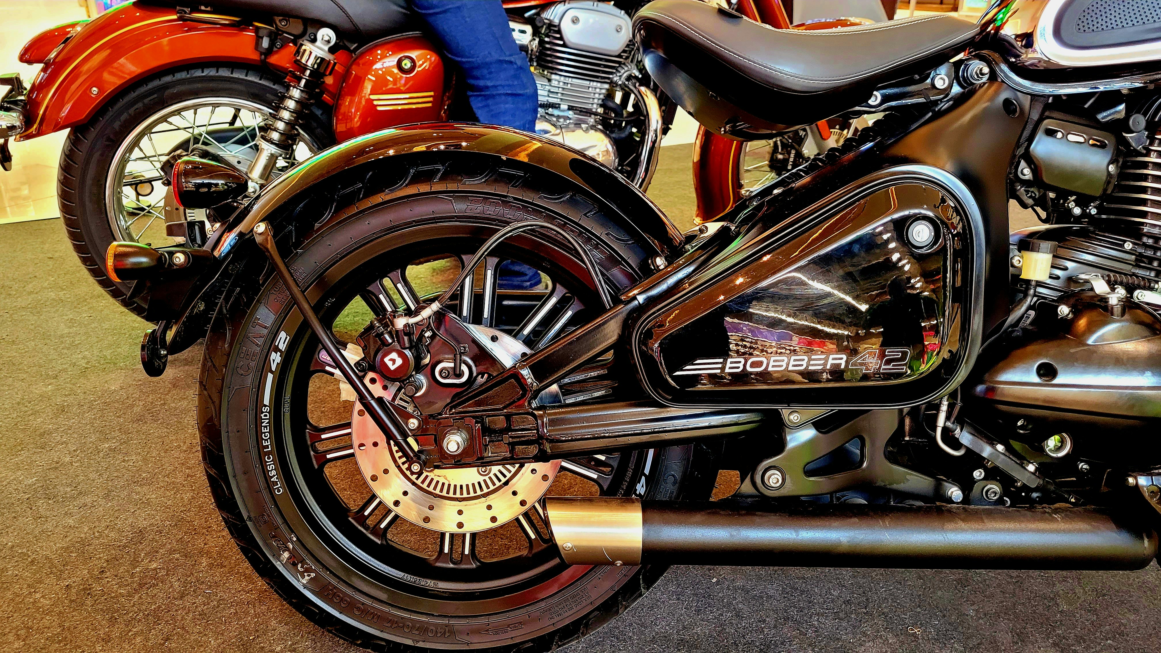 A black motorcycle's rear wheel, fender, and exhaust pipe