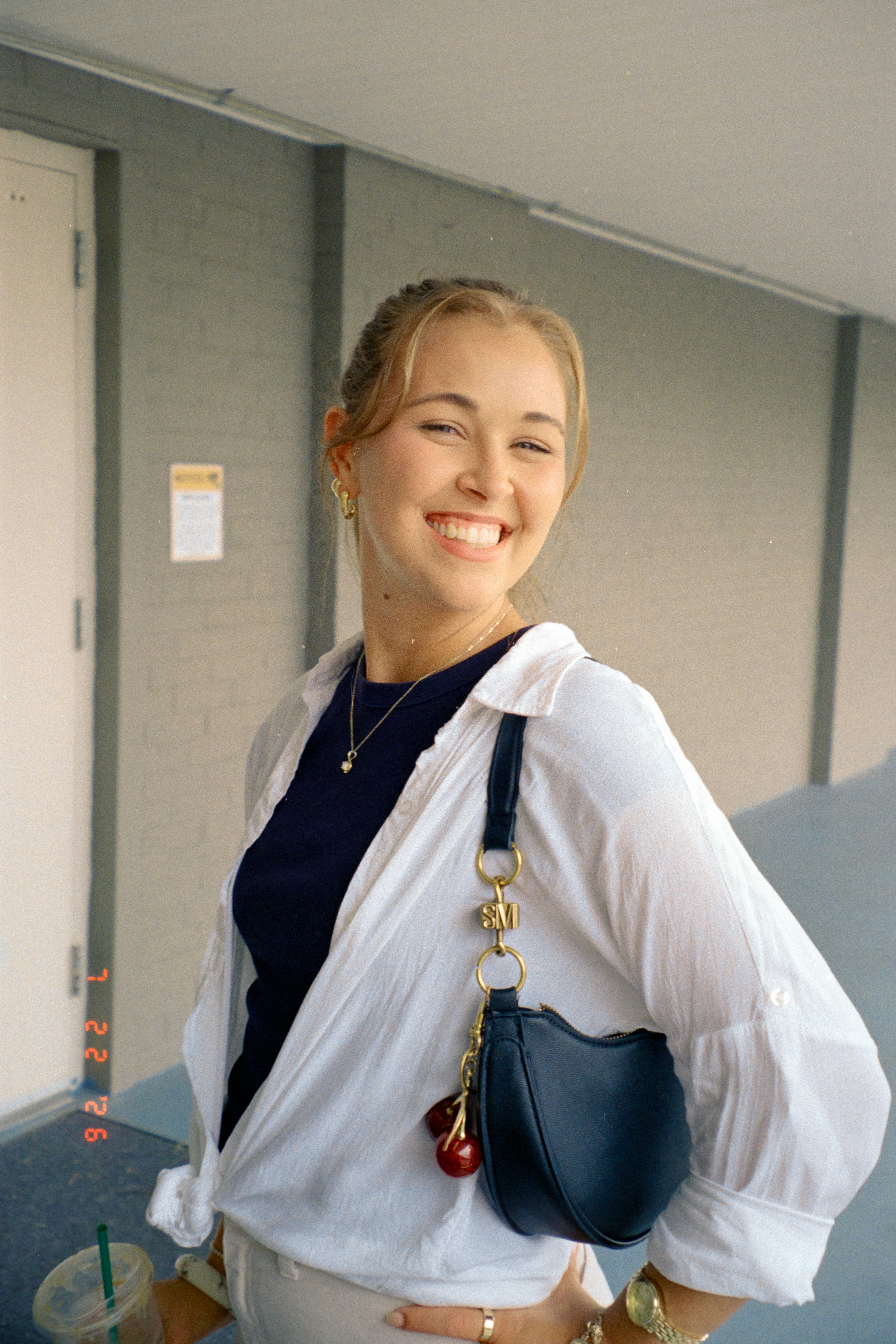 Smiling young woman holding a purse and coffee cup