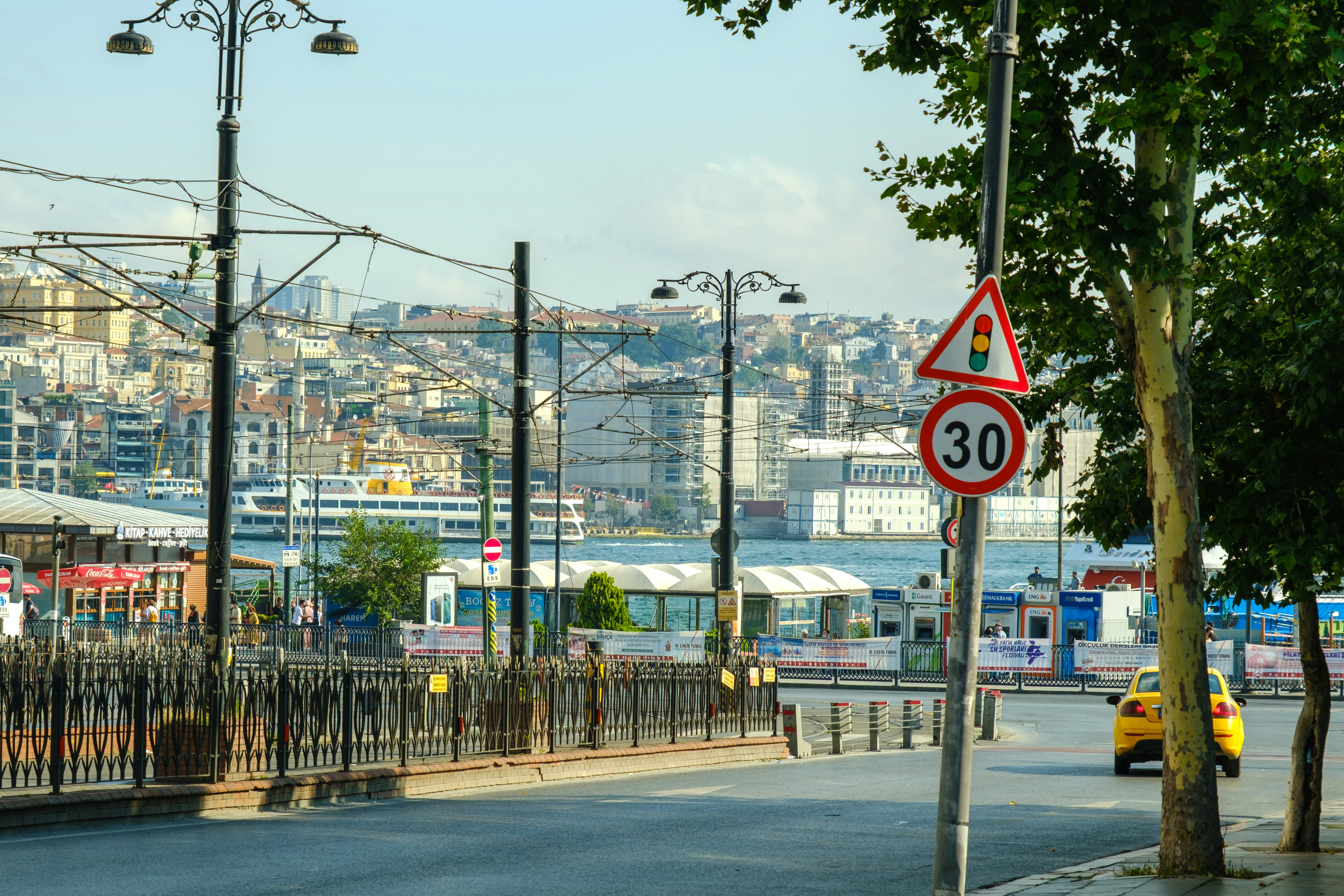 A street with a 30 km/h sign and city skyline.