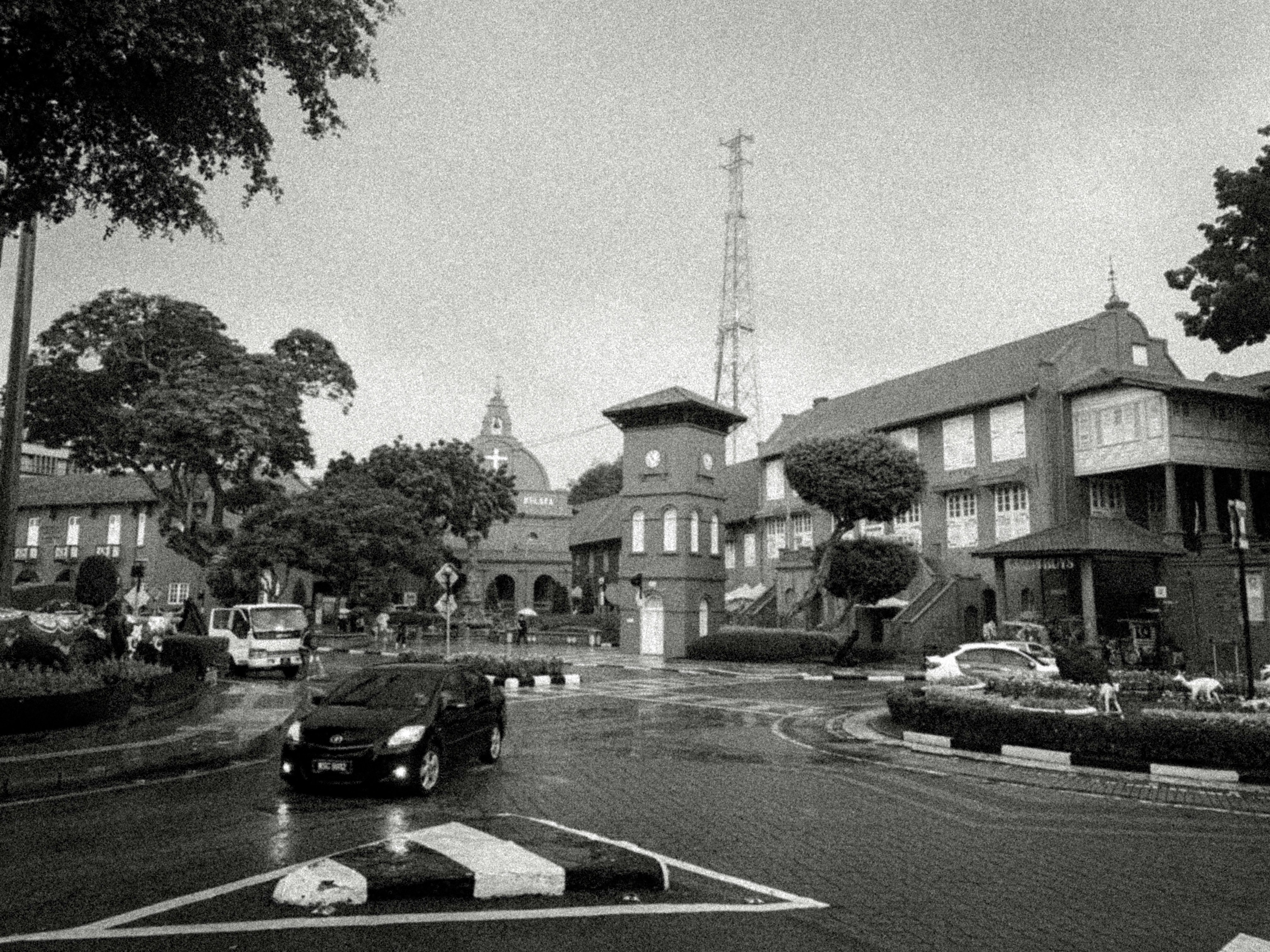 Black and white street with a car and historic building