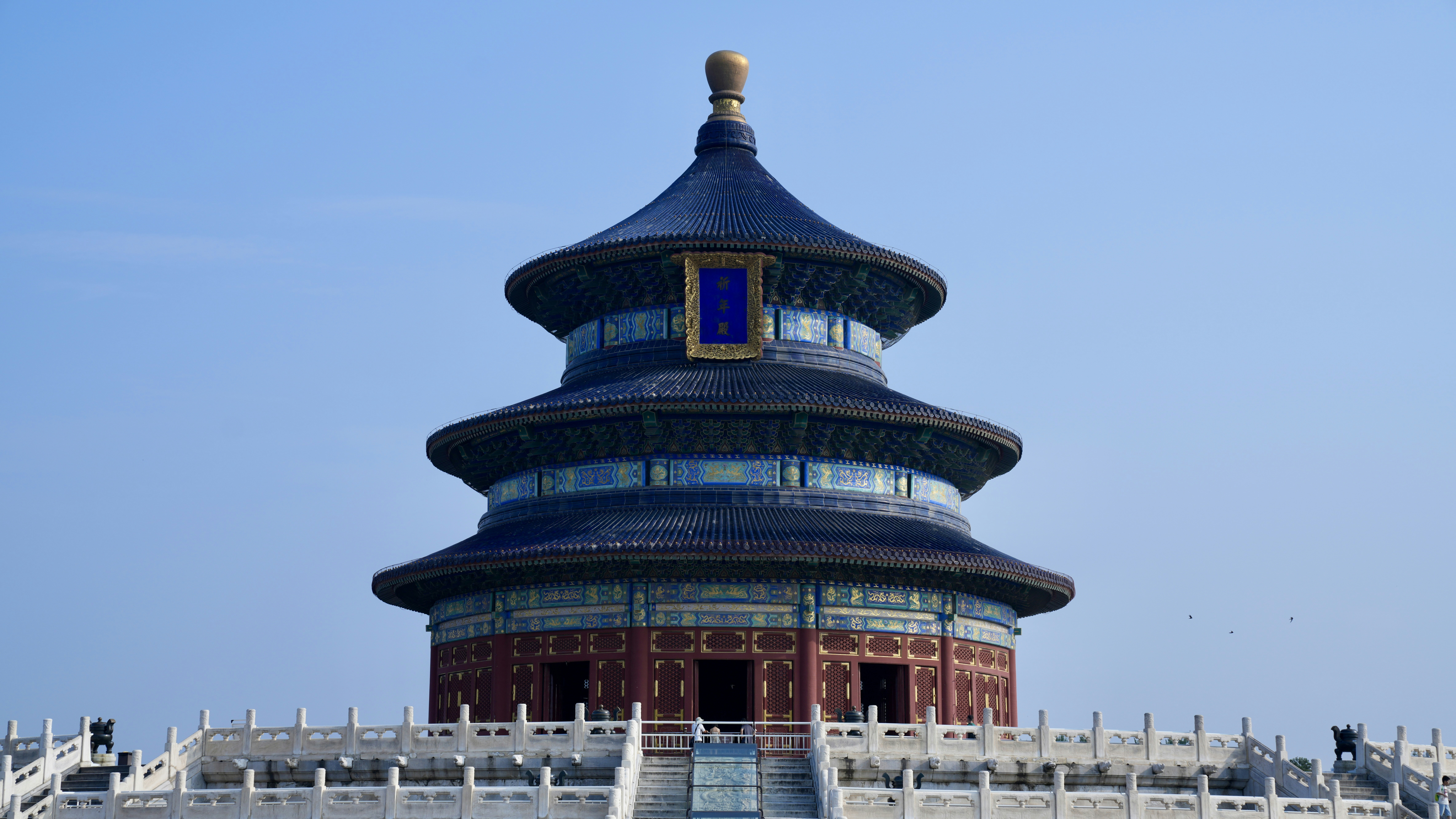 Ornate traditional chinese temple building against a clear blue sky.