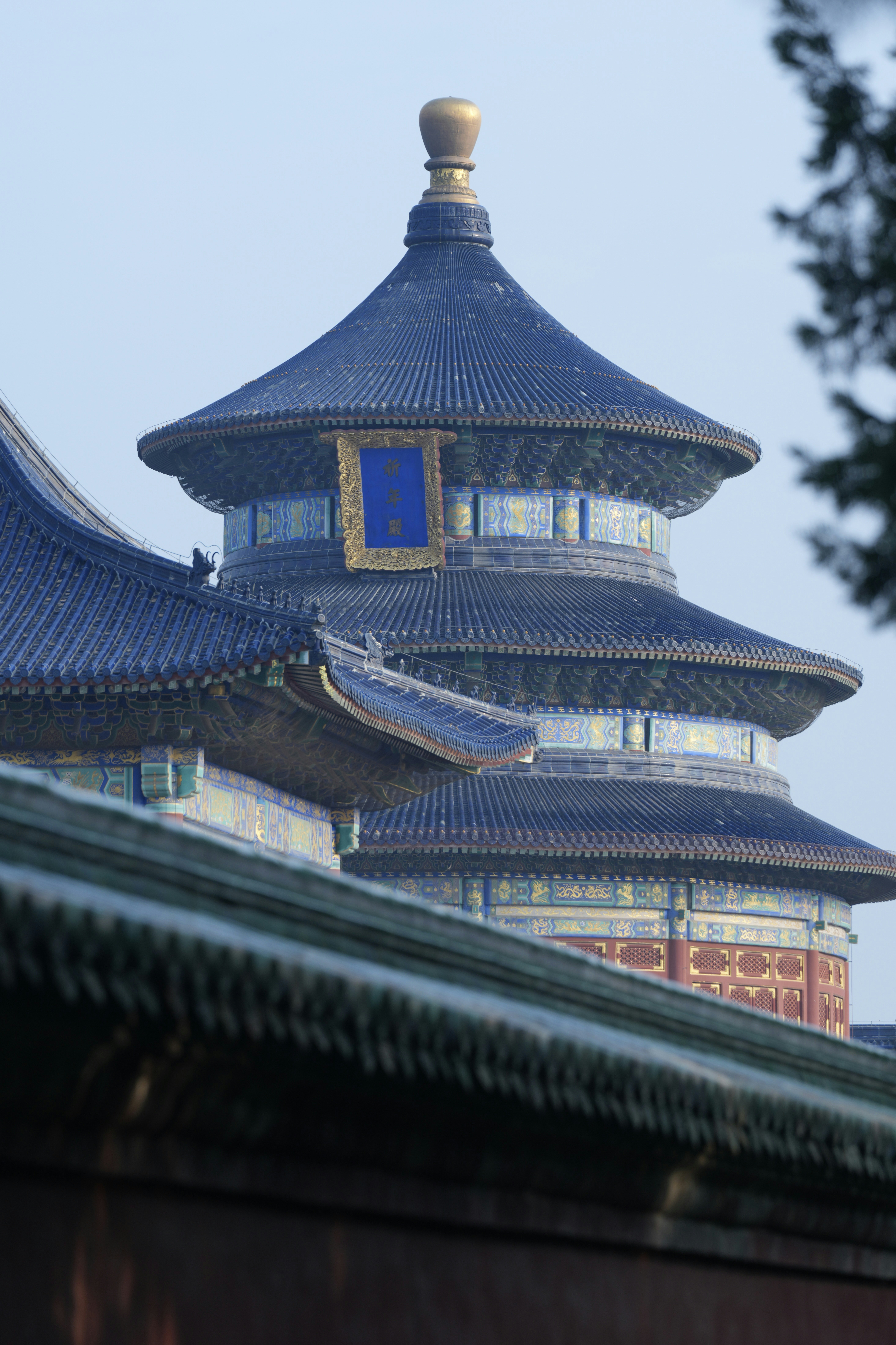 Ornate blue-roofed chinese temple building against a clear sky.