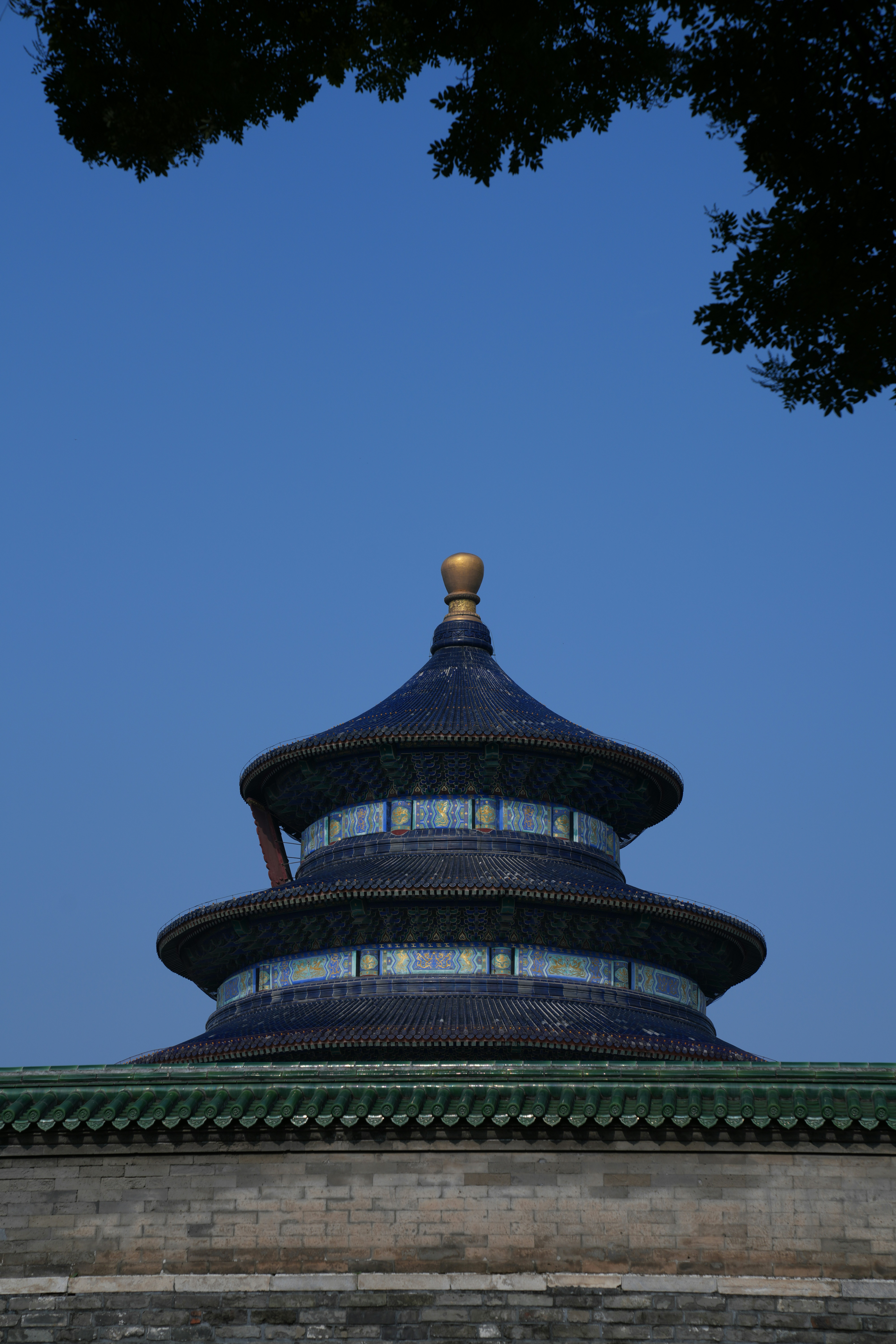 Ornate blue-roofed temple against a bright clear sky.