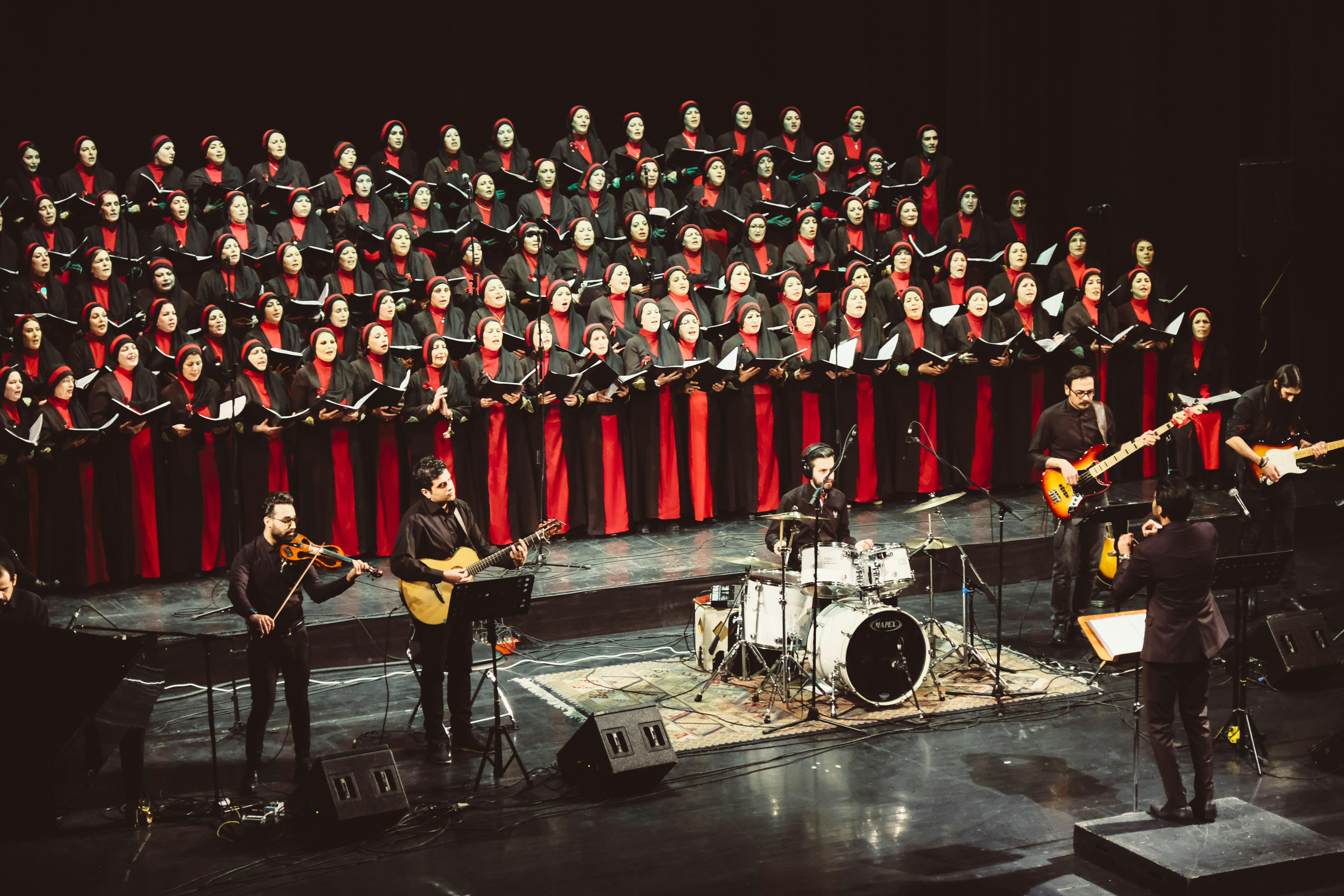 A choir and band performing together on stage