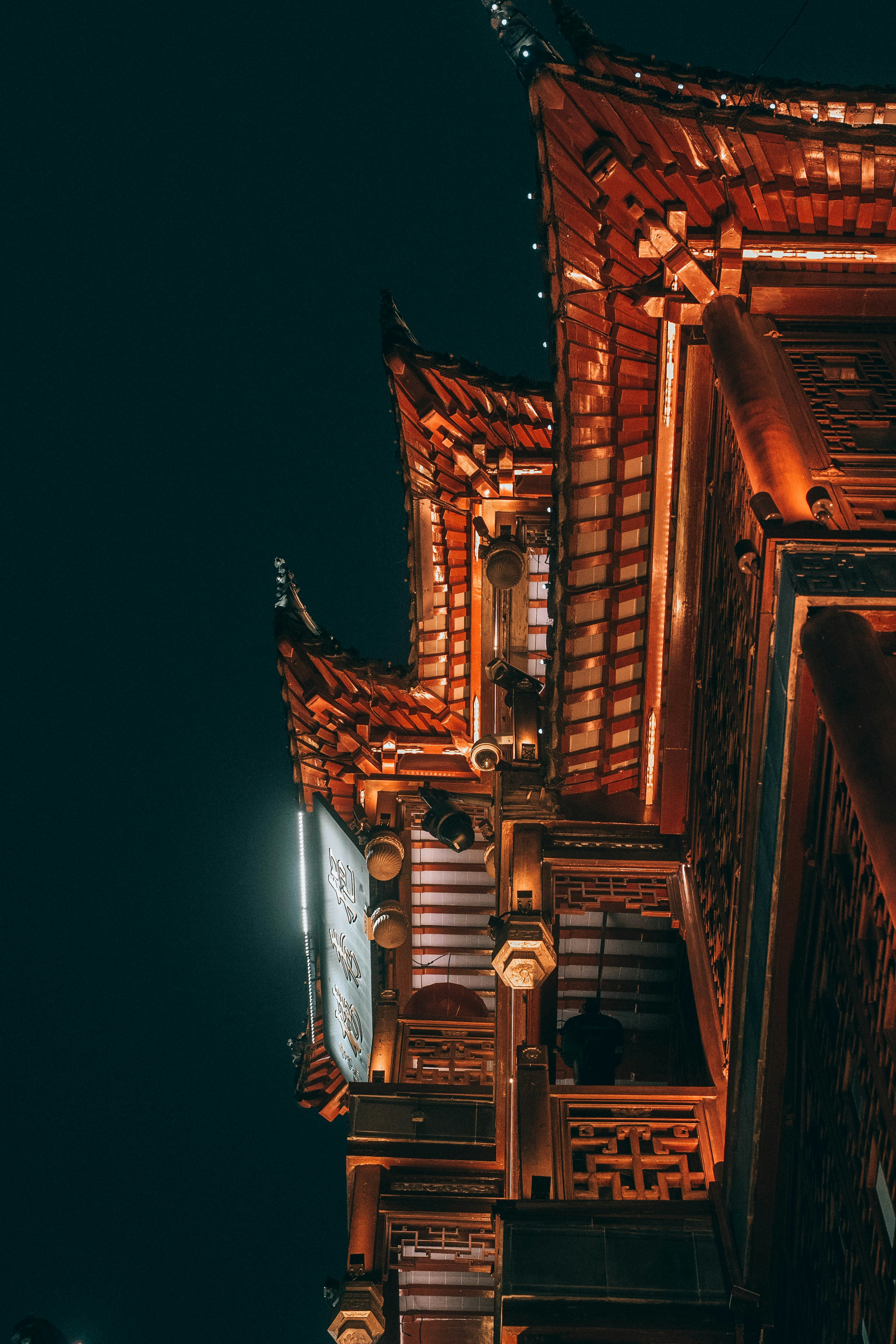 Traditional asian building with illuminated orange roofs at night