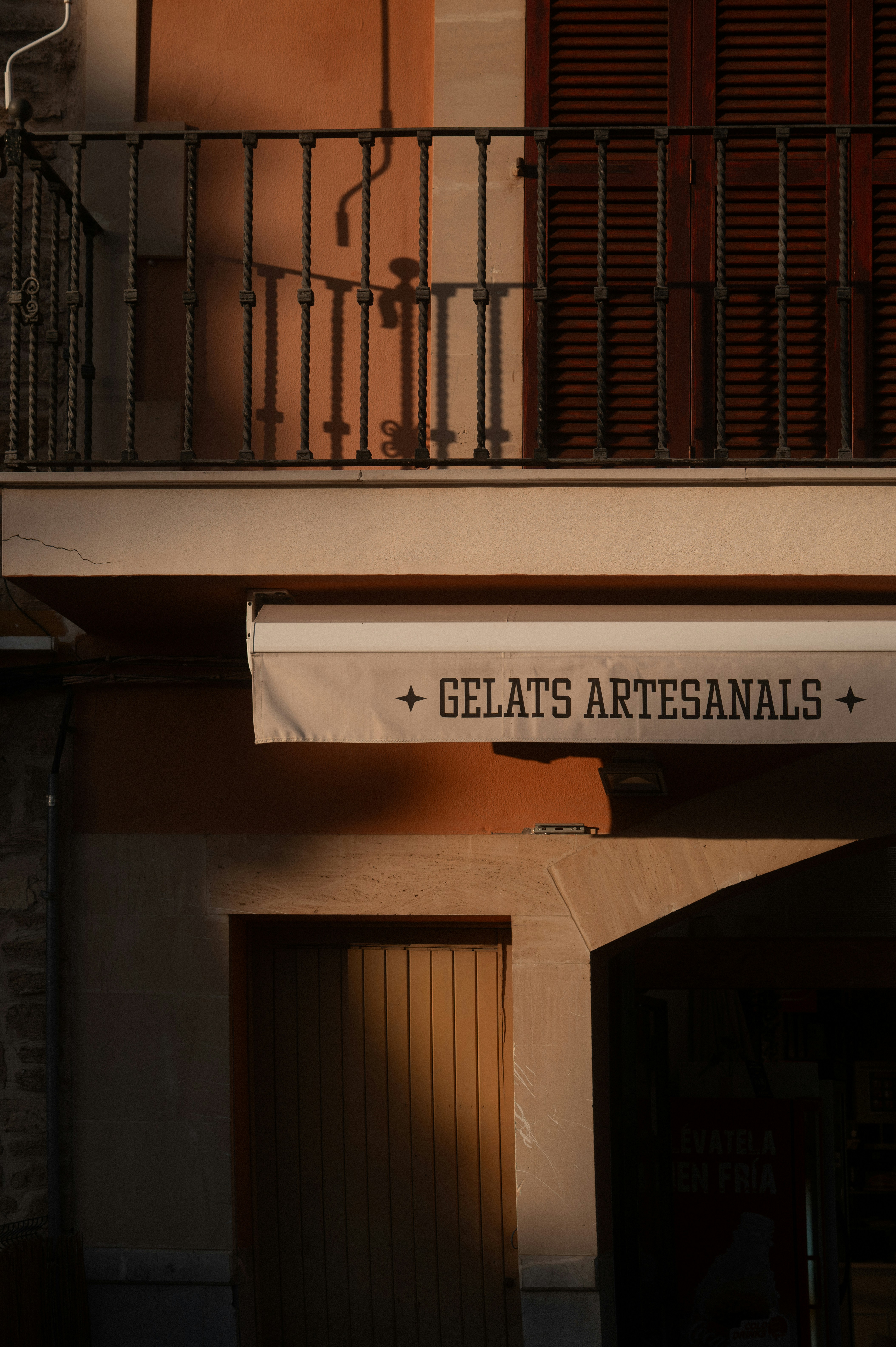 Facade with balcony, shutters, and "gelats artesanals" awning.