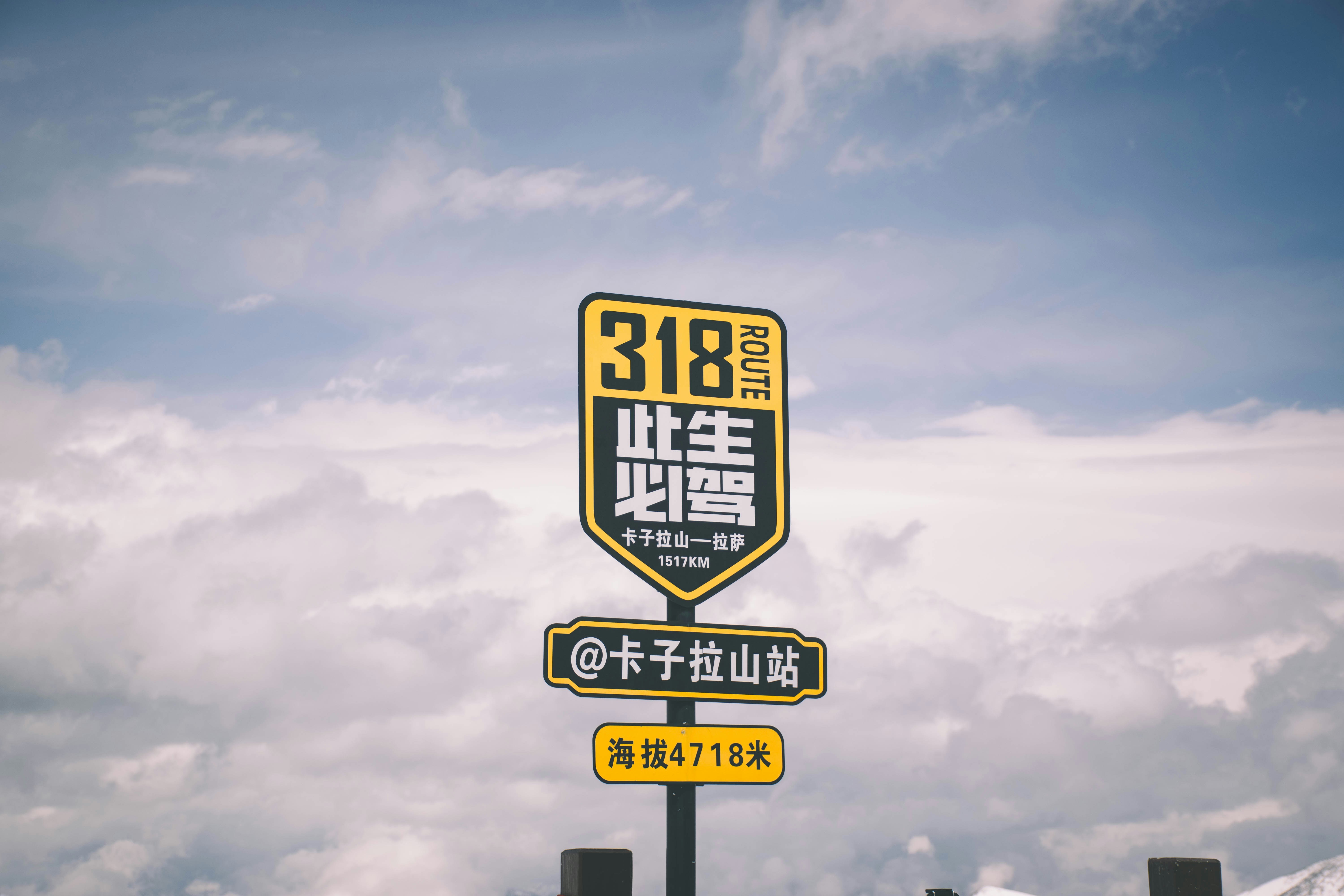 흐린 하늘 아래 중국어가 적힌 도로 표지판 "318".