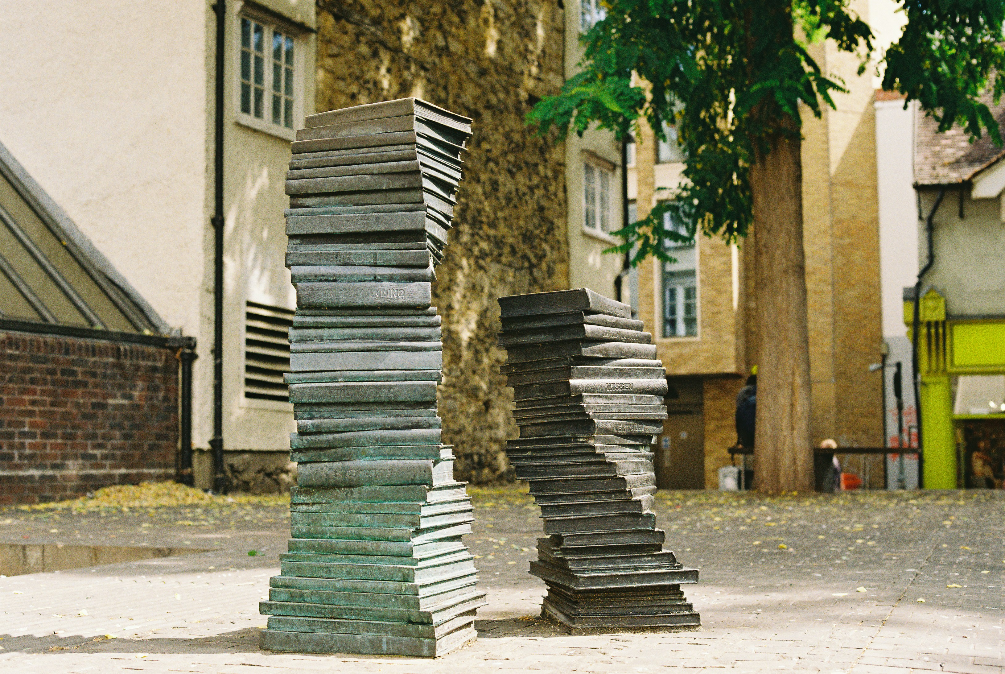 Two abstract sculptures resembling stacked books outdoors