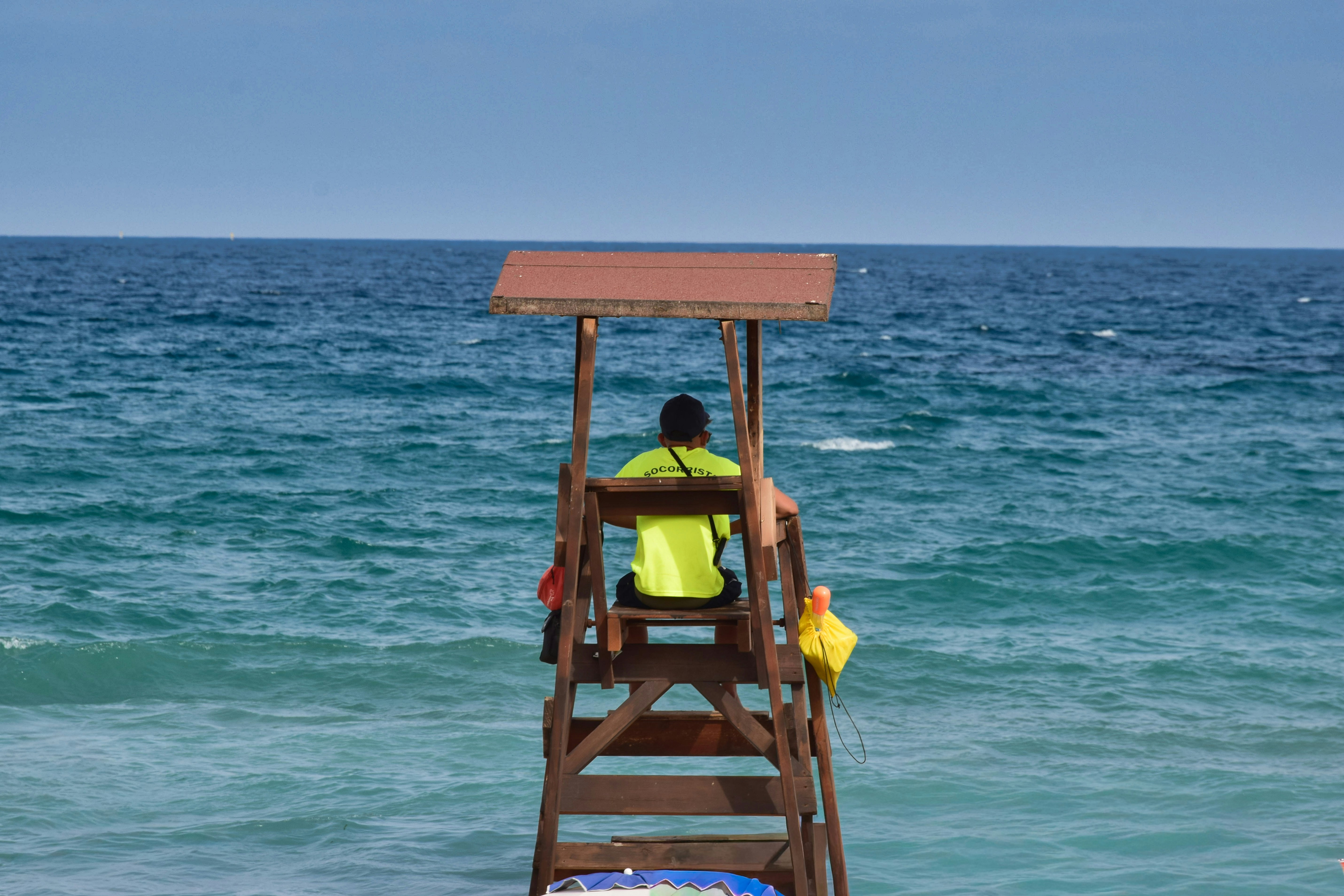 Lifeguard on a high chair watching the blue ocean