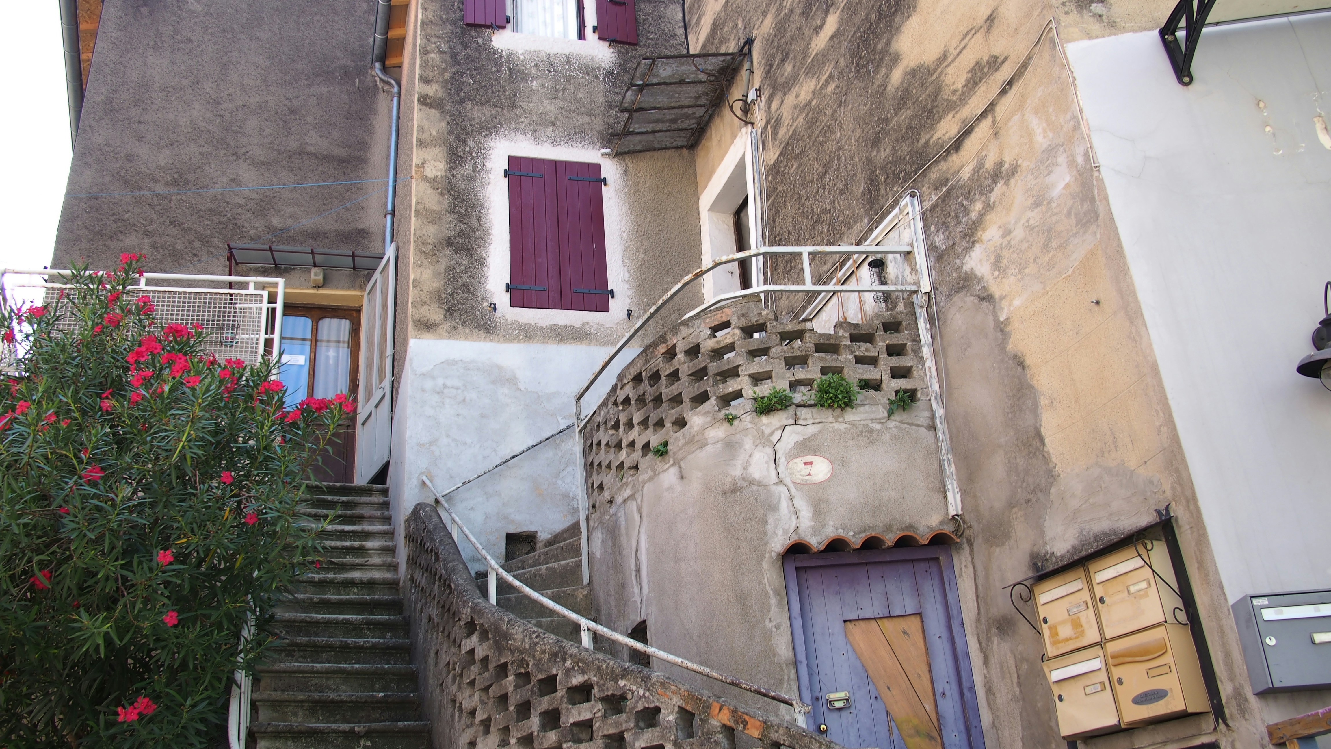 Old stone stairs wind through ancient buildings with purple accents