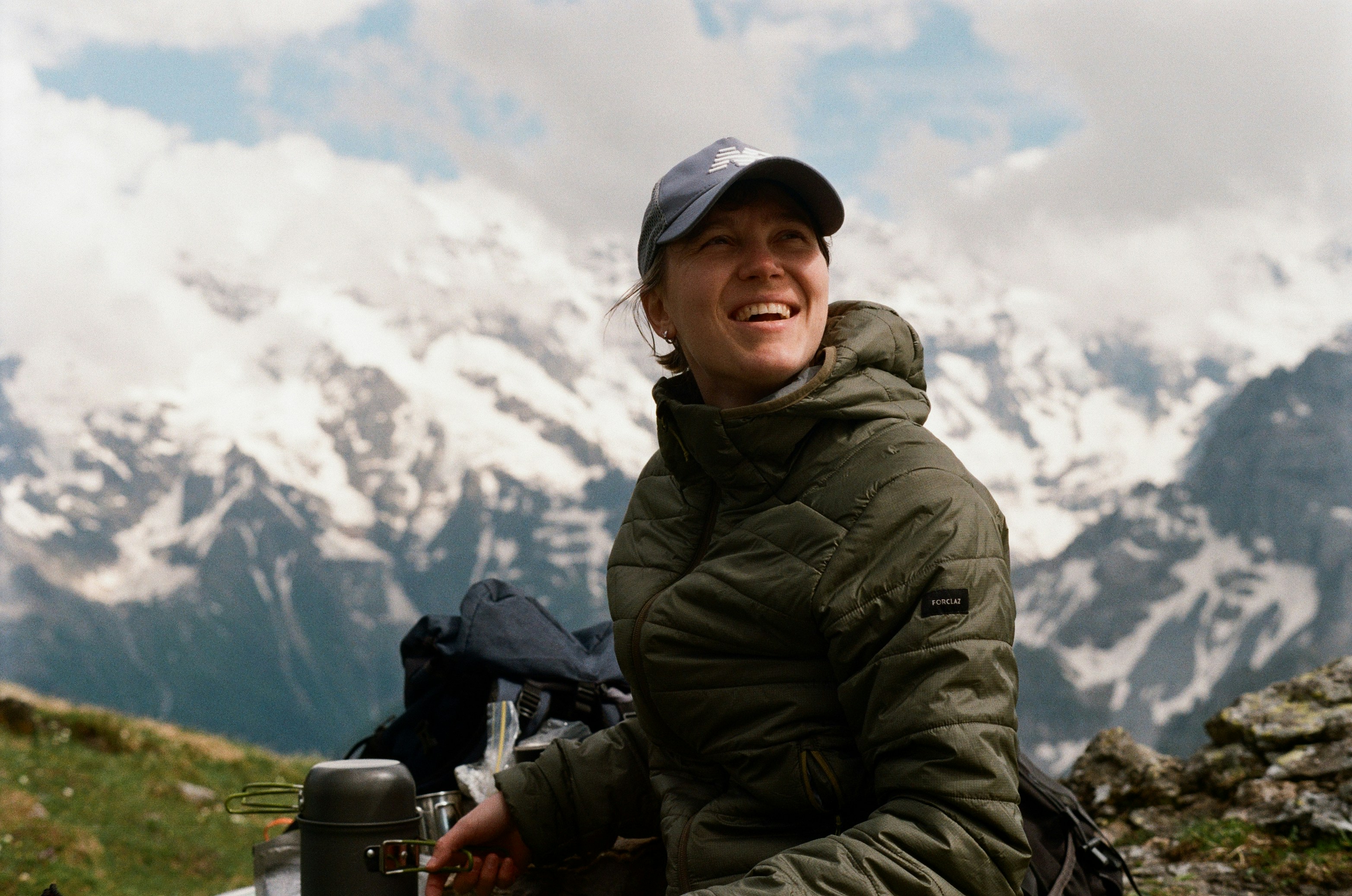 Smiling woman in a jacket enjoys snowy mountain view