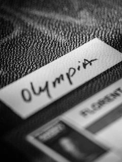 Black and white label "olympia" on a textured background