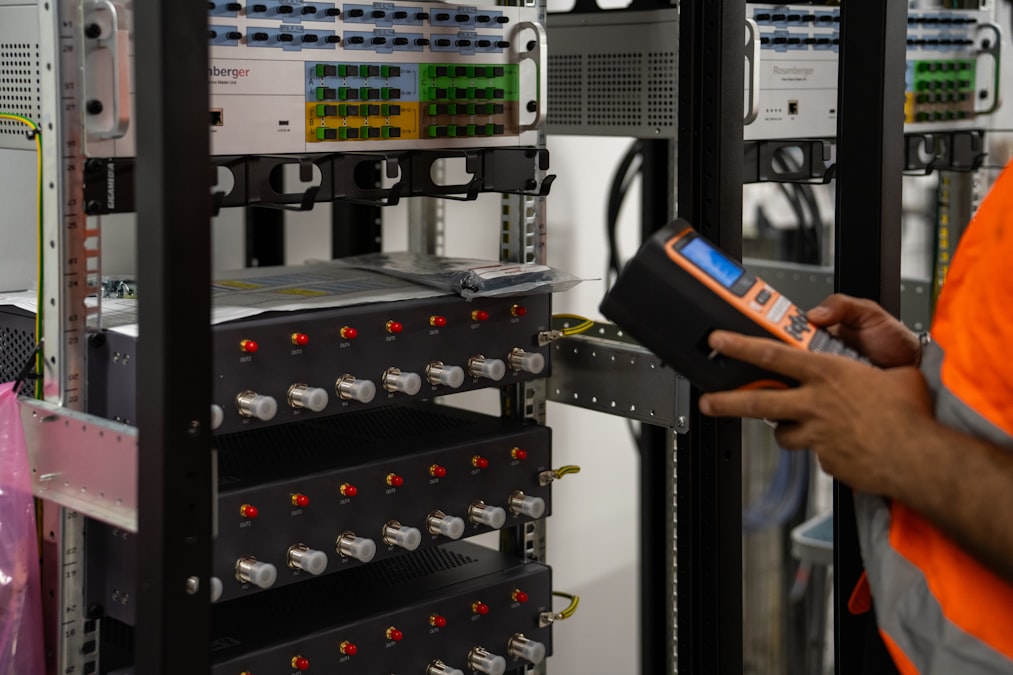 Technicus controleert serverrekken in een datacenter met een handmeter