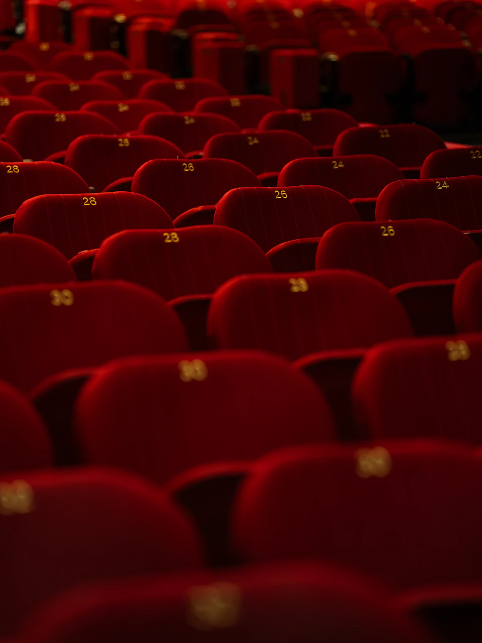 Red velvet theatre seats with yellow numbers