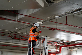 Construction worker on lift installing ceiling components