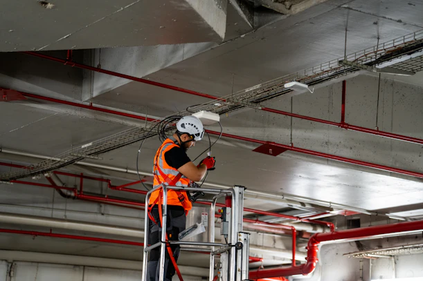 Construction worker on lift installing ceiling components