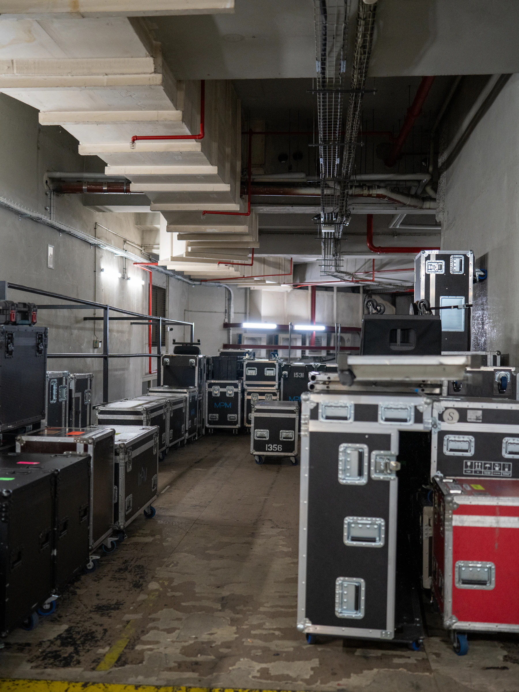 Rows of black flight cases stacked in a kit store