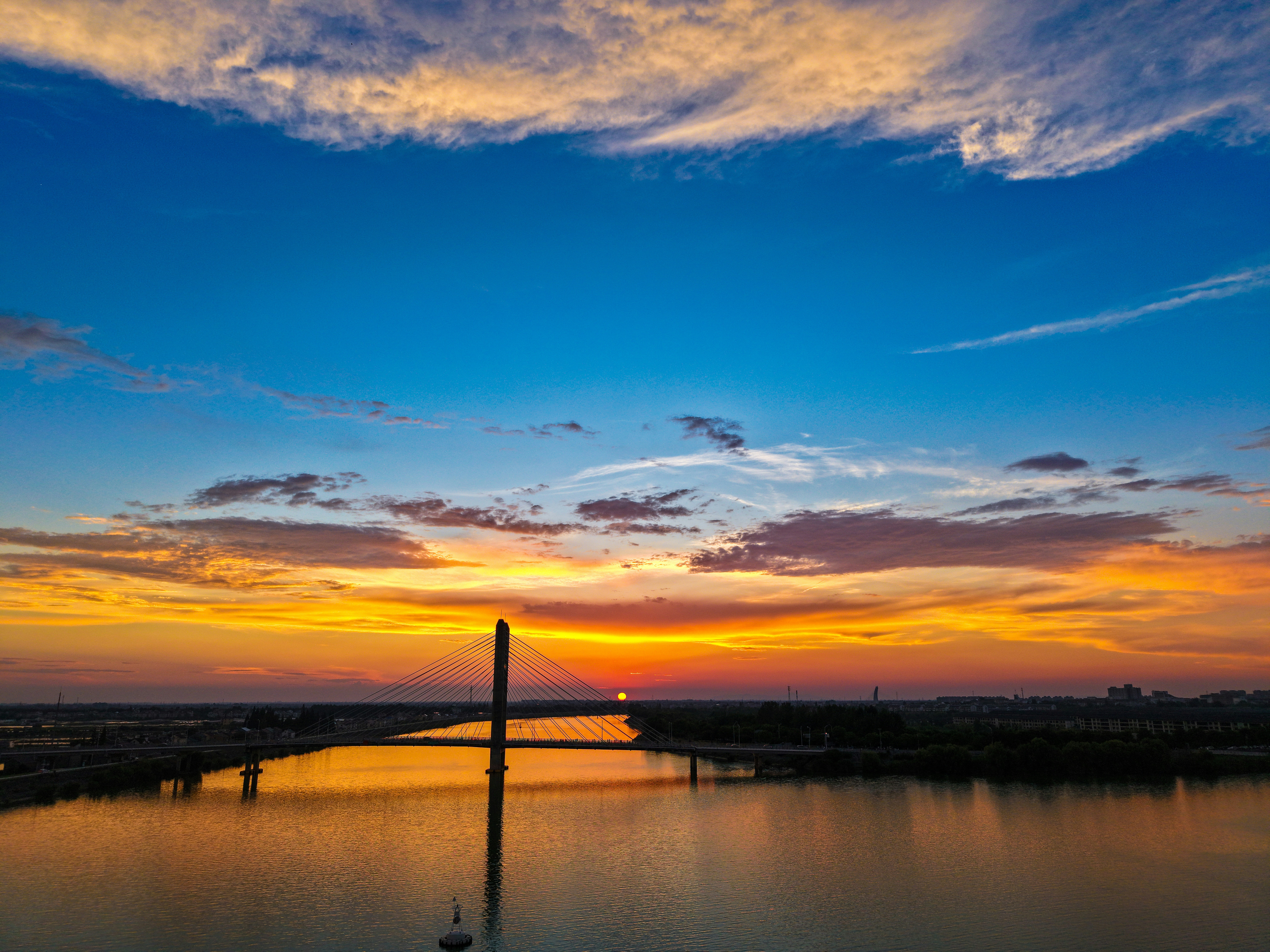 Vibrant sunset over a river with a bridge reflection