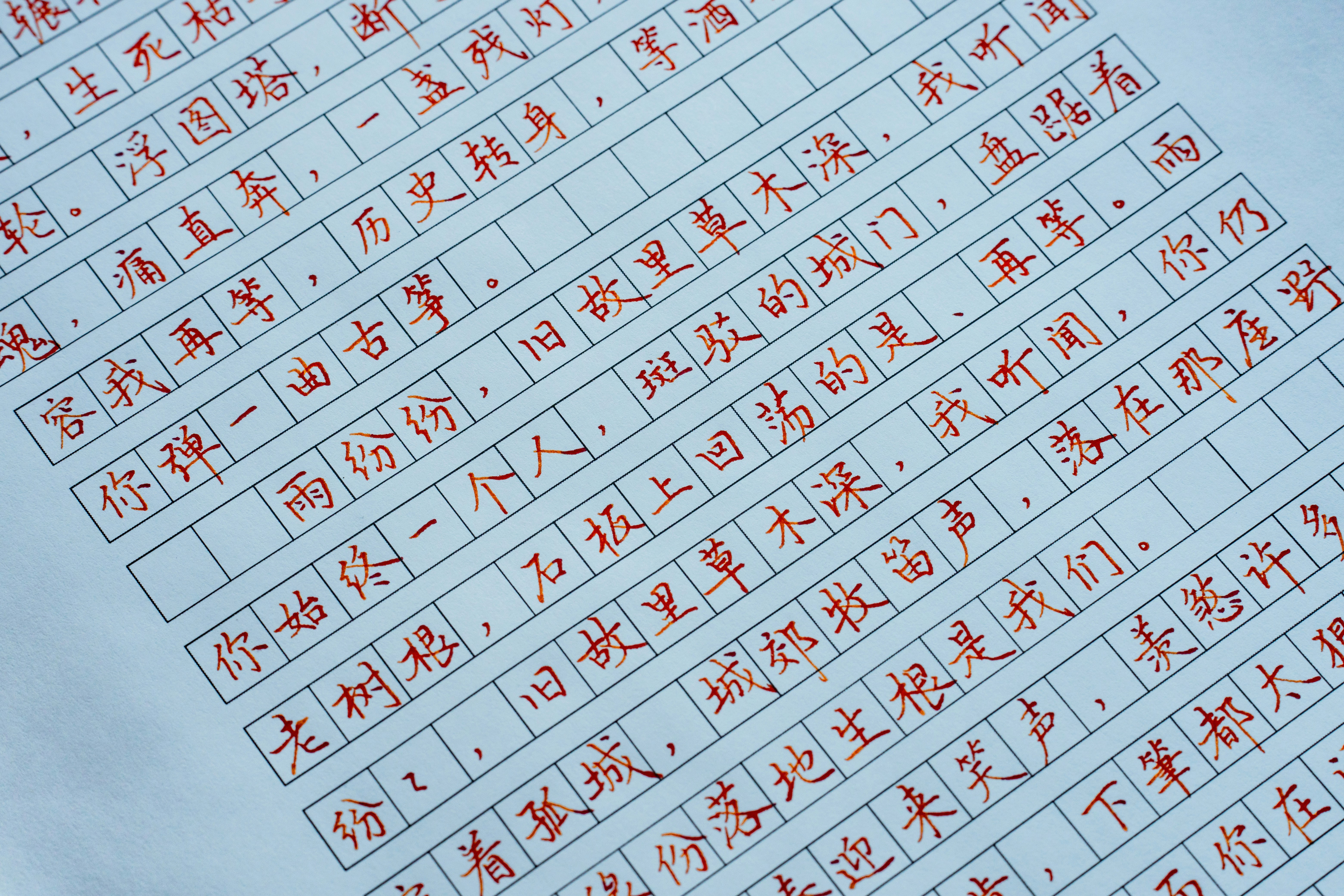 Handwritten chinese characters in red ink on gridded paper
