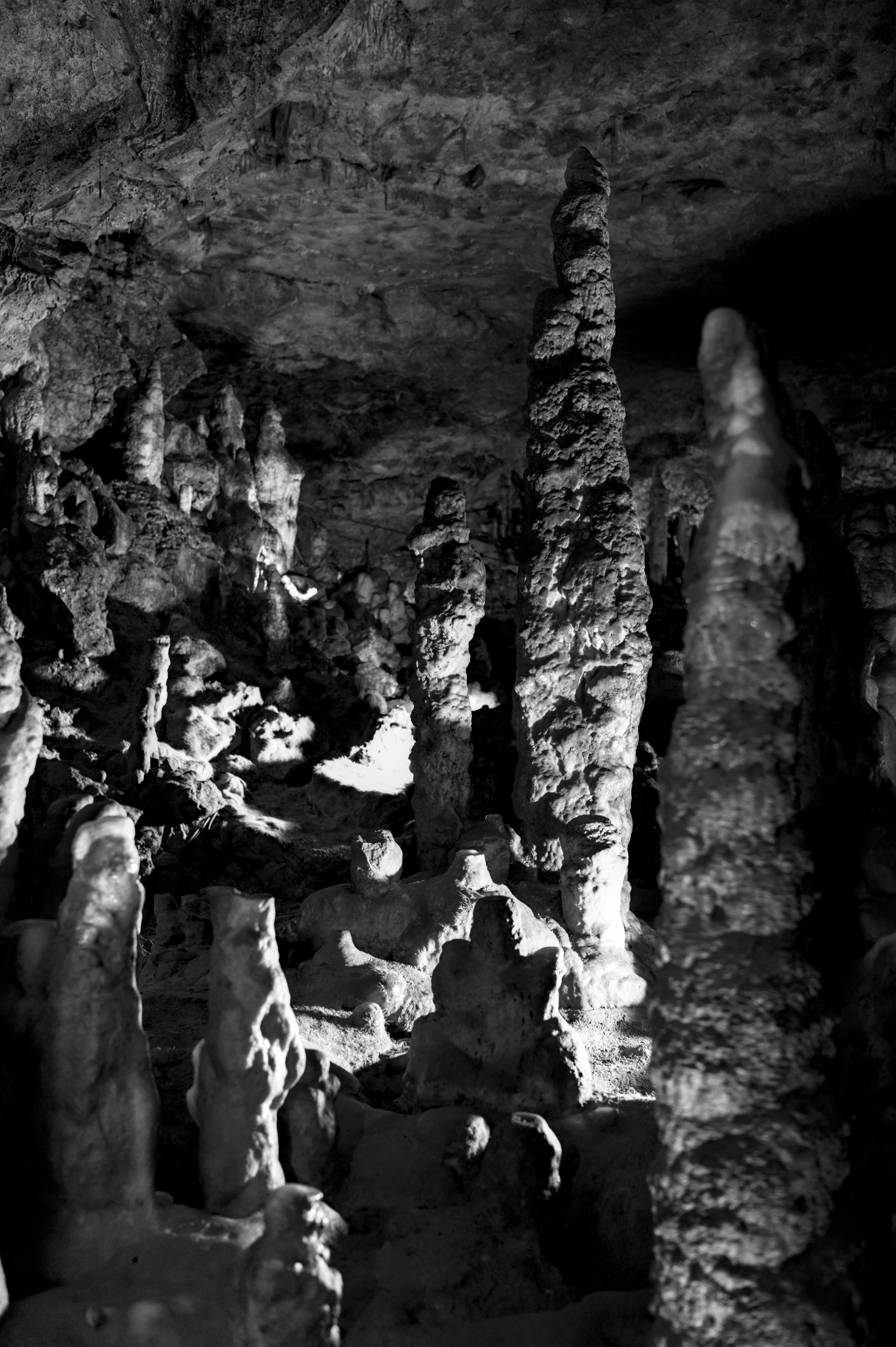 Dramatic black and white cave interior with towering rock formations.