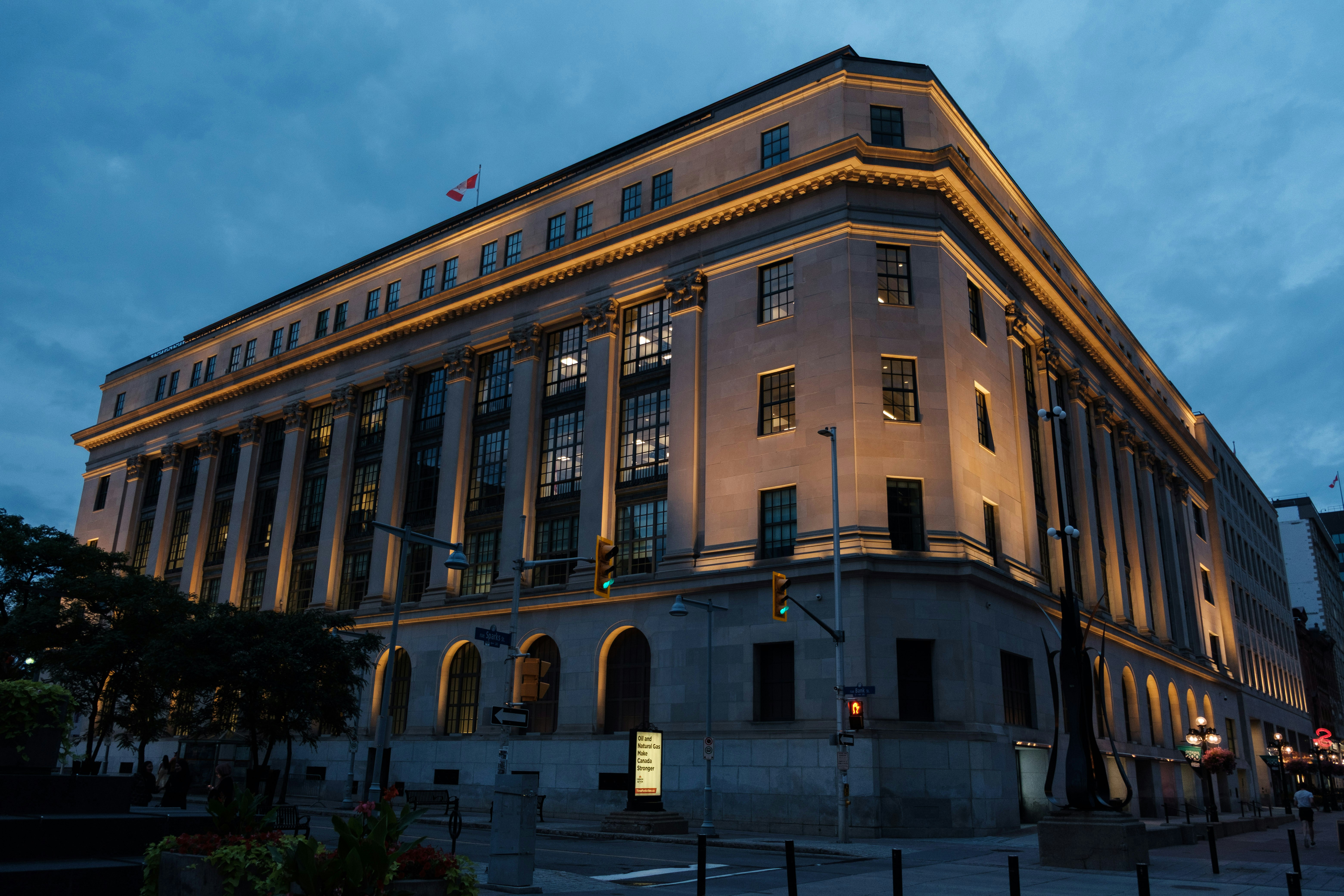 A large, illuminated classical building at dusk with dark sky.