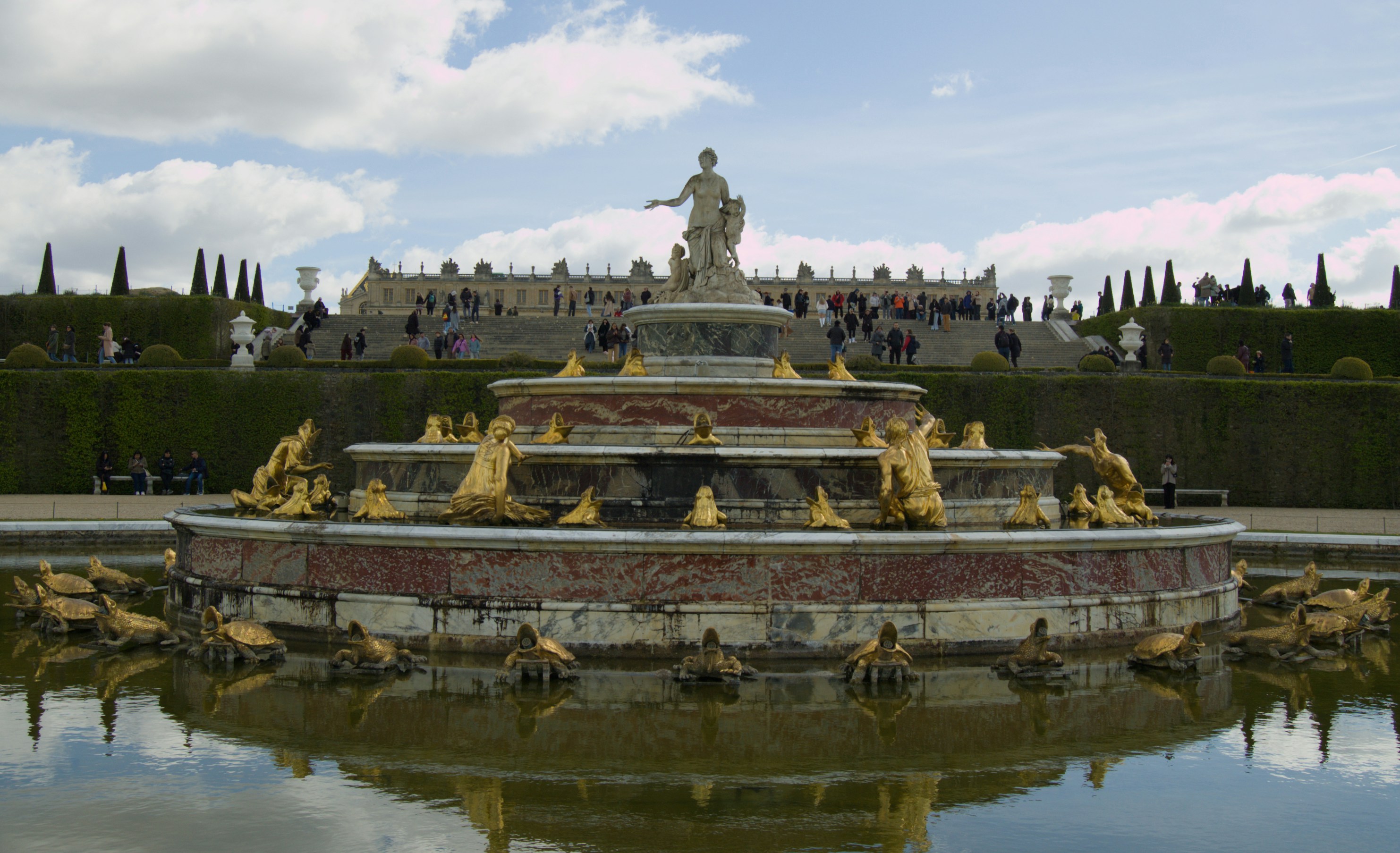 Majestic fountain with golden statues reflecting in water