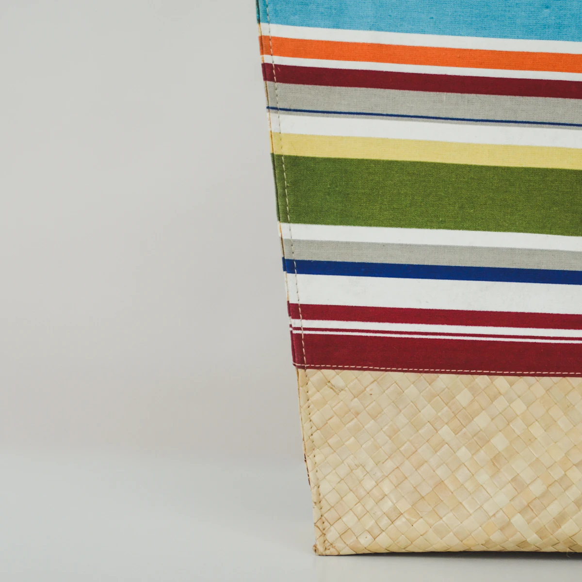 Colorful woven bag detail with a natural straw base