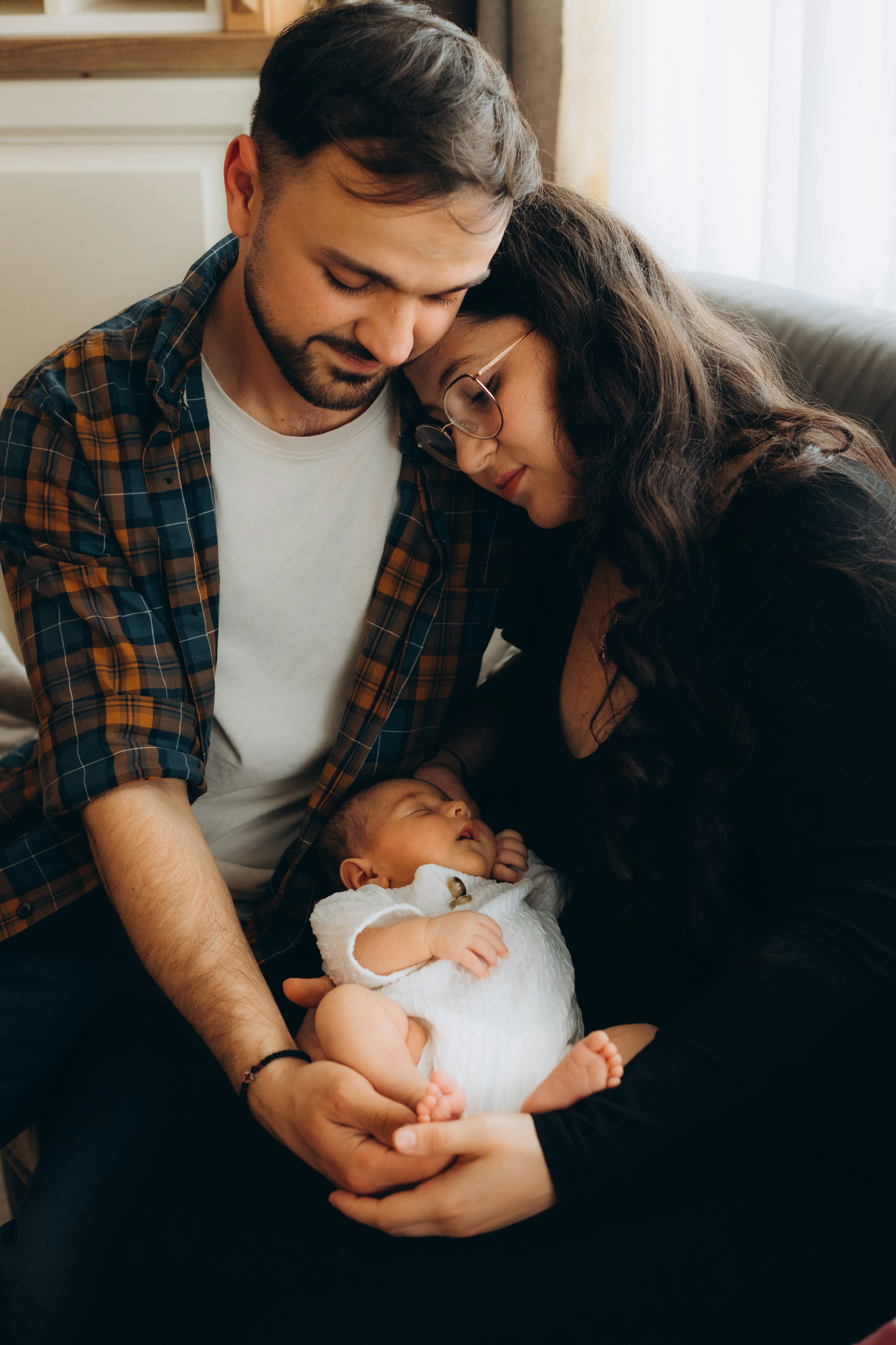 A loving couple holding their newborn baby.