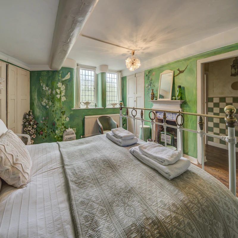 Quarto real aconchegante com parede verde-floresta e lareira