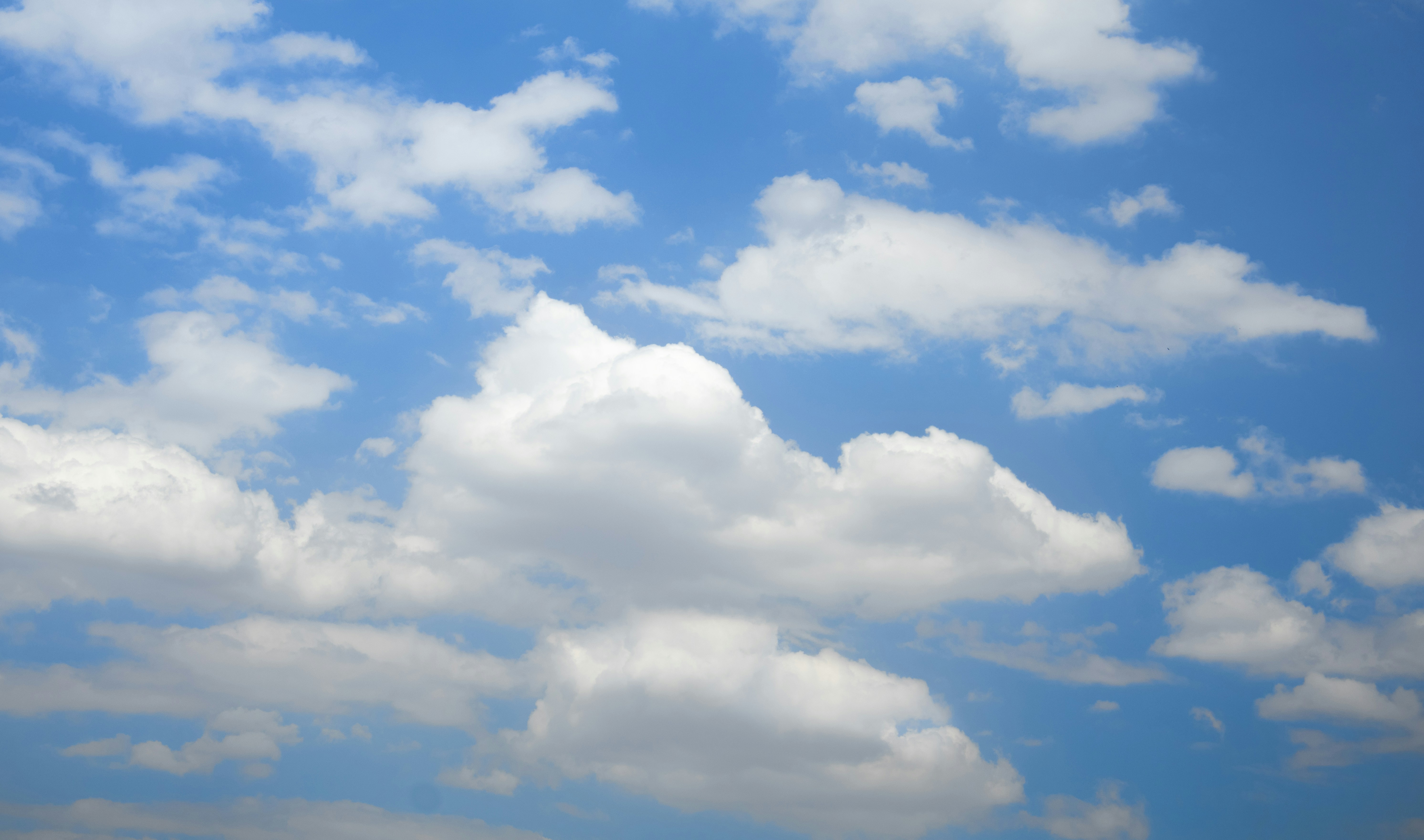 A bright blue sky filled with white fluffy clouds