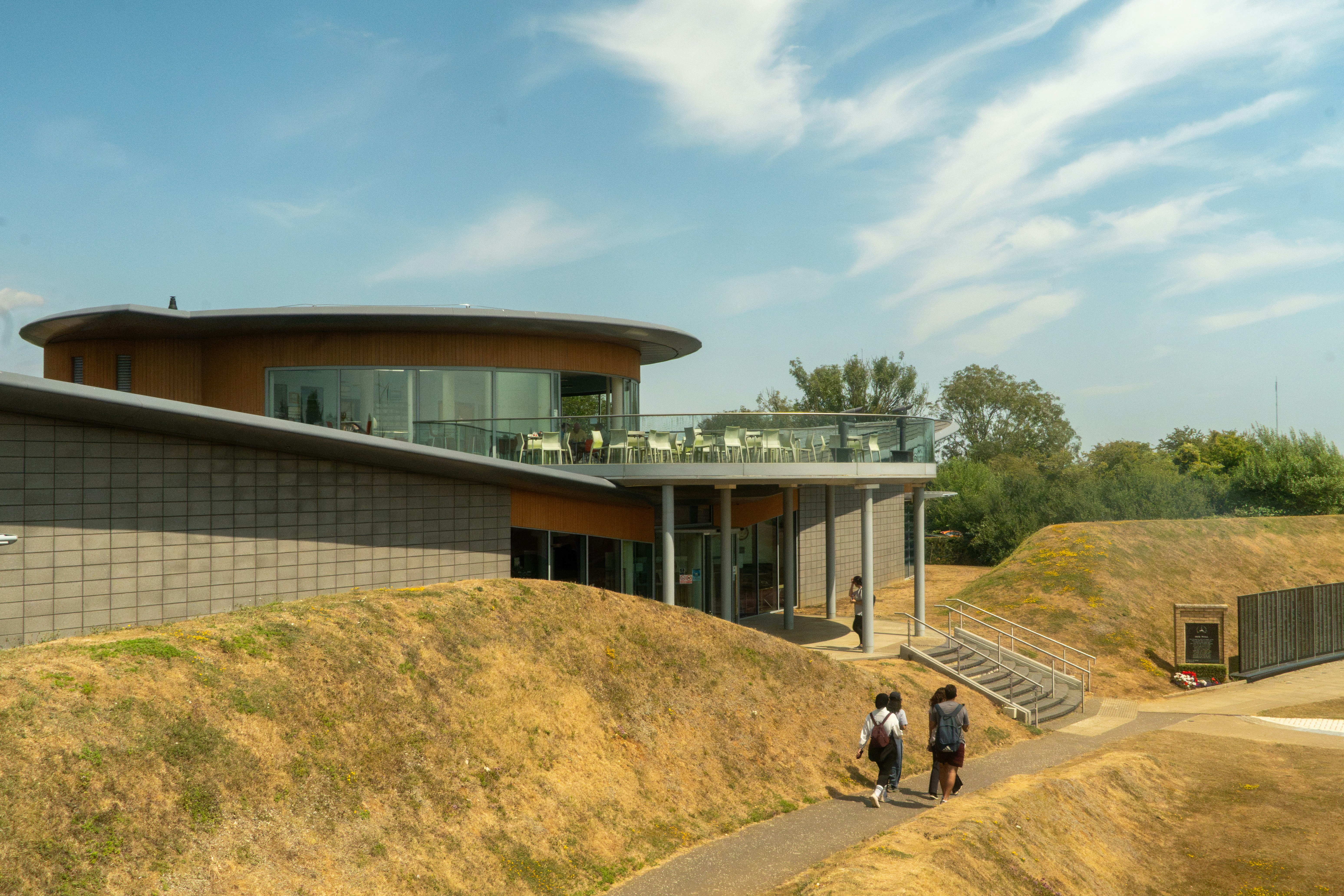 Modern building with circular balcony and grassy mounds