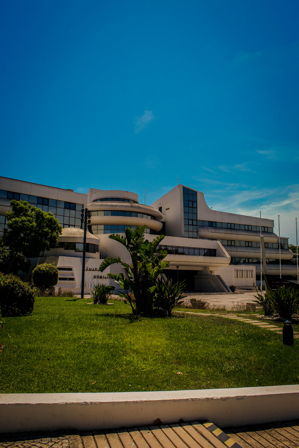 Gedung perkantoran modern dengan halaman rumput hijau