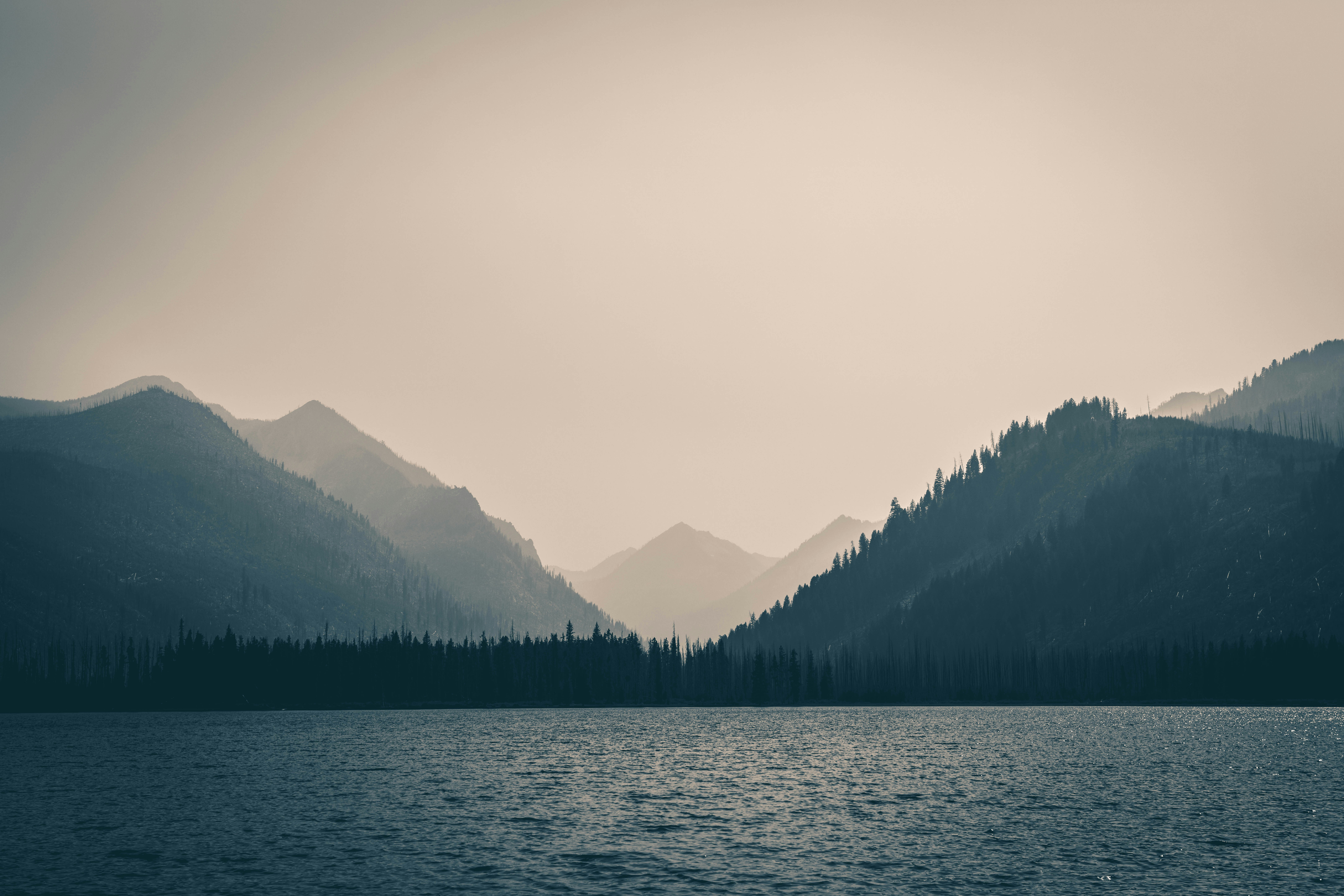 Misty mountains over a calm lake