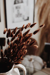 Decorative dried brown grass in a white vase