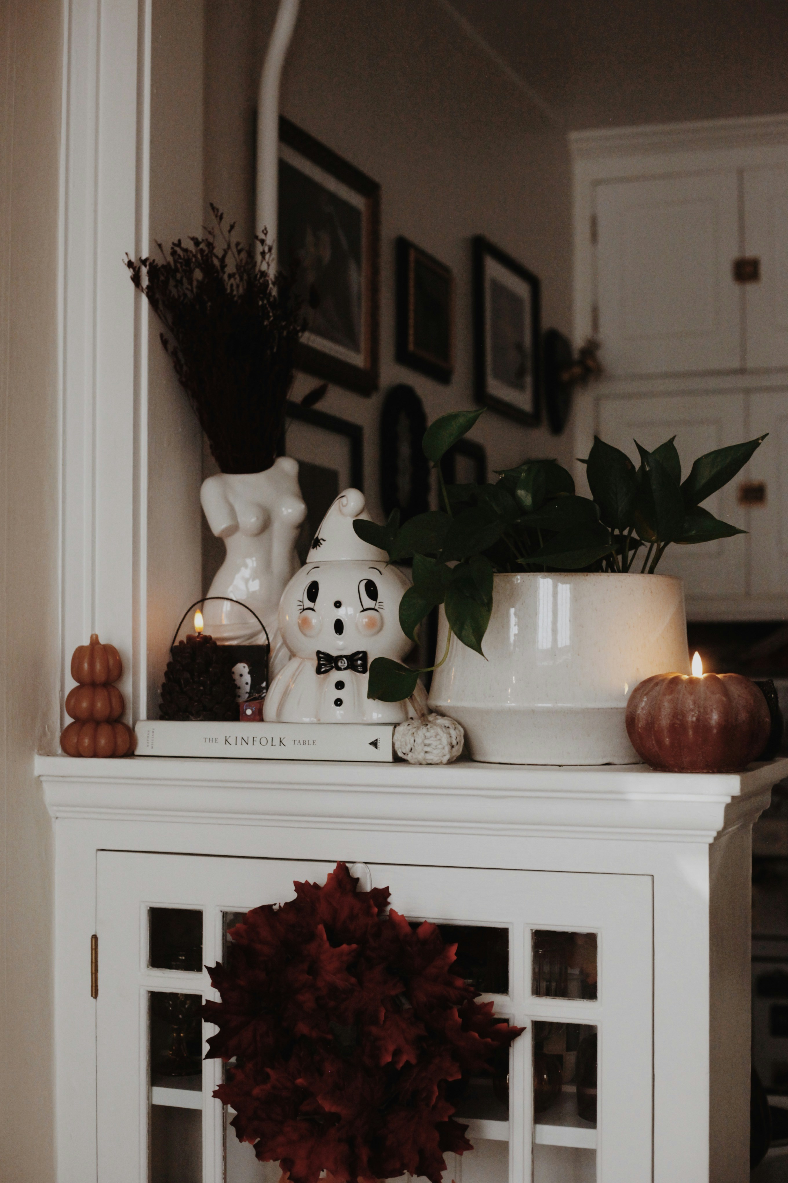 Spooky ghost, pumpkins, and fall decor on a white cabinet