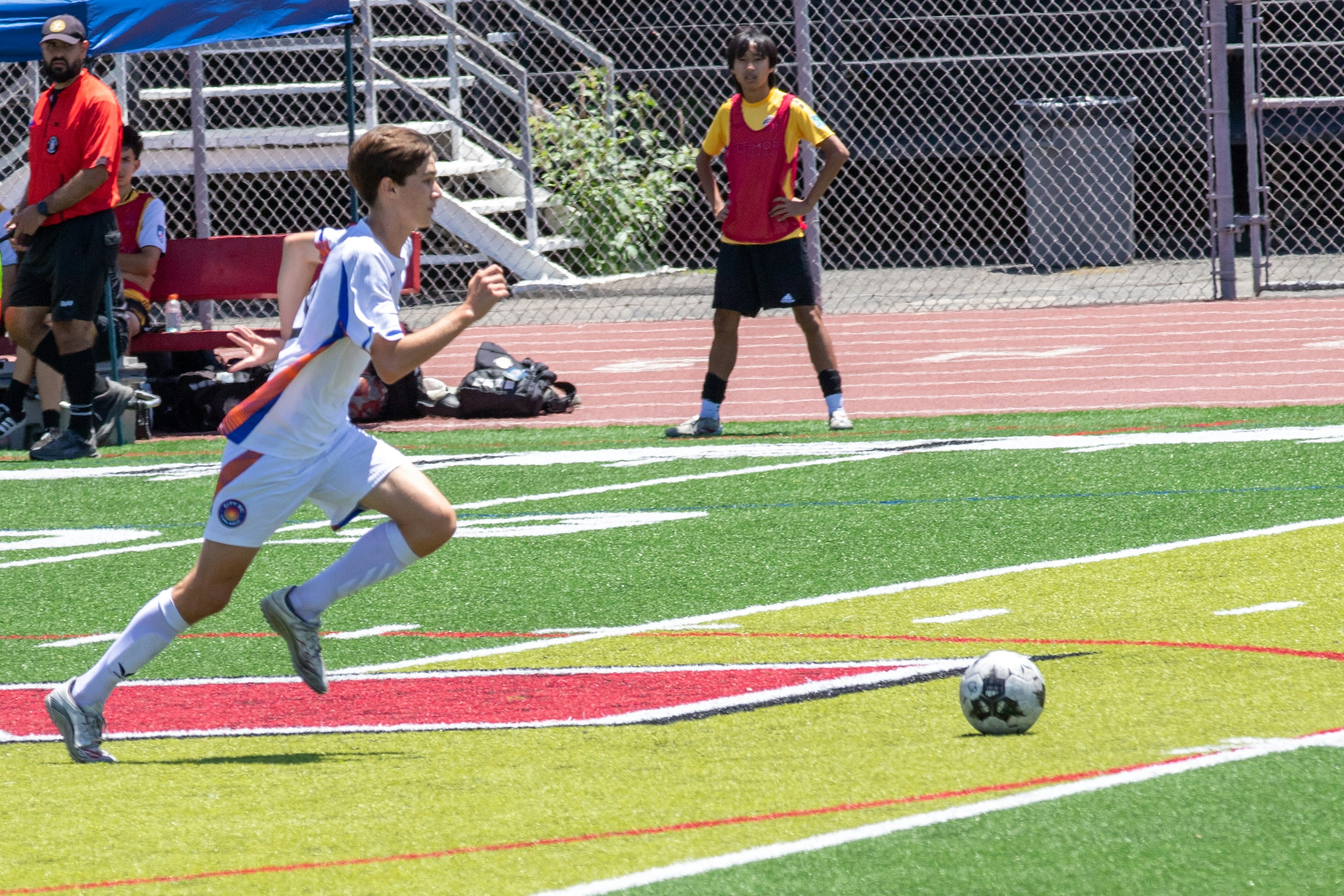 Young soccer player running with ball on a green field