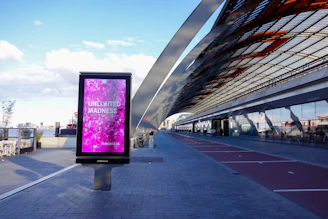 Modern digital billboard with pink abstract art outdoors