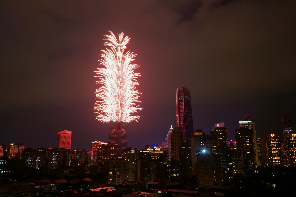 跨年夜台北101施放新年煙火，周邊是信義區夜景