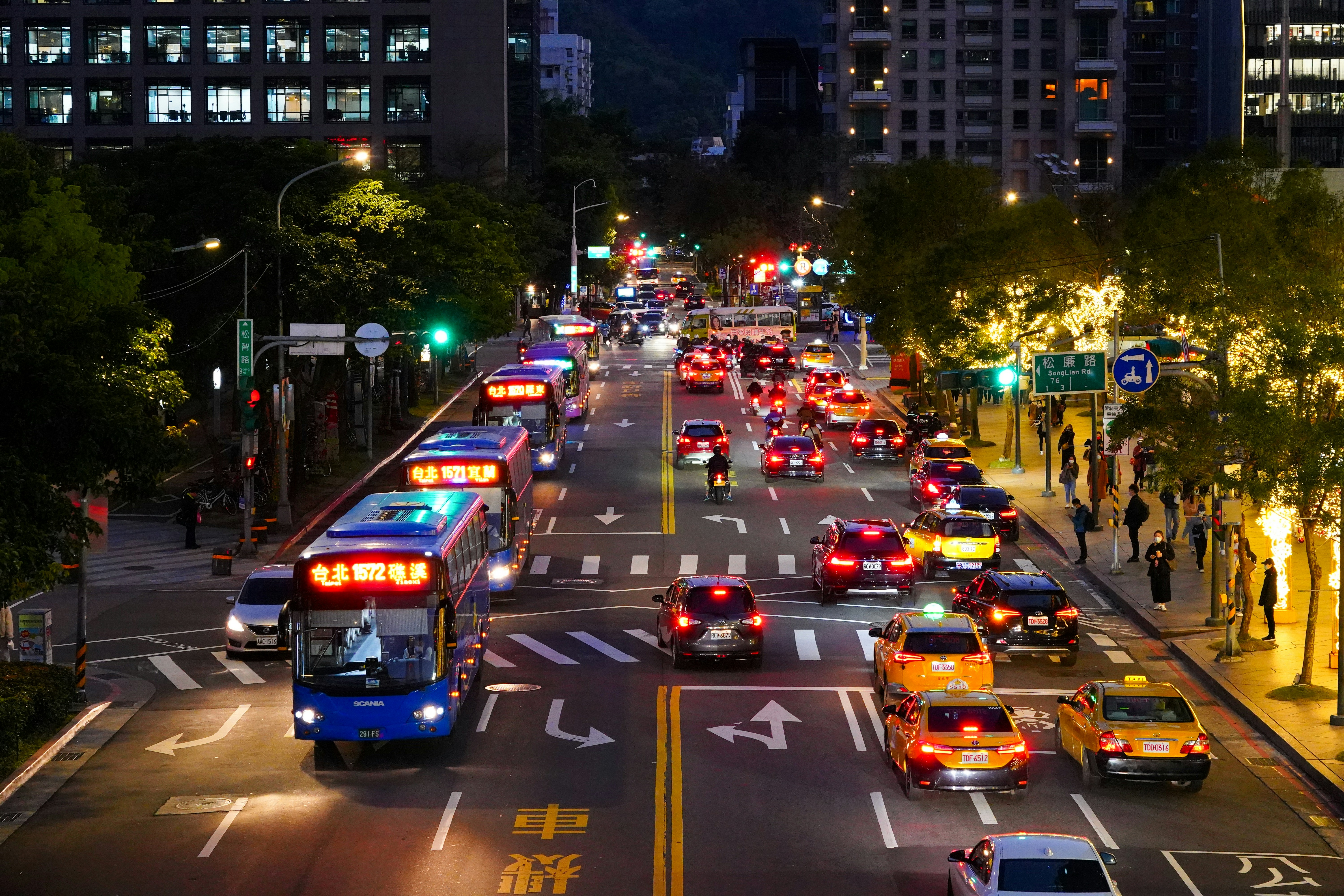 Busy city street at night with cars and buses